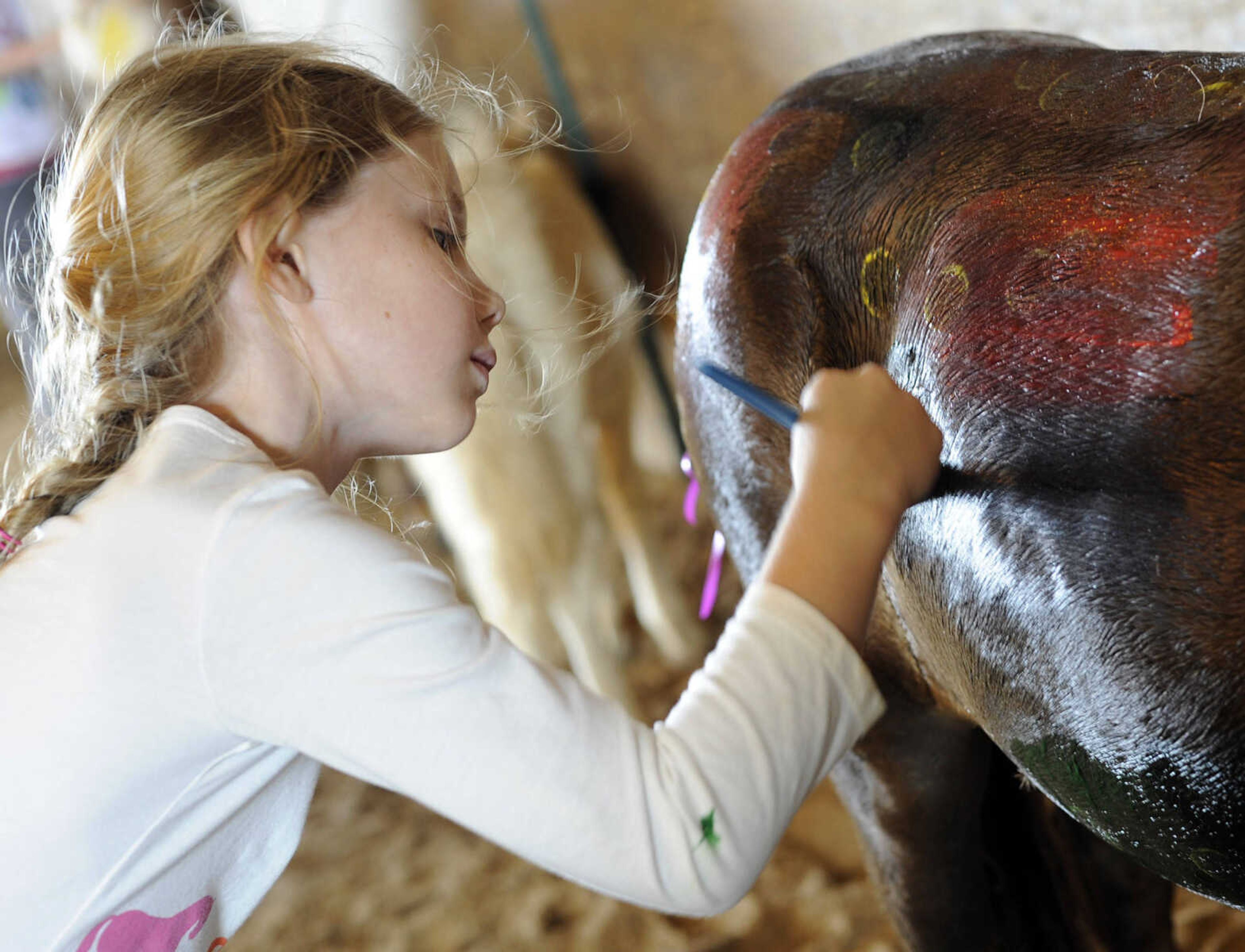 Morgan Curtis paints Chippy at a horseback riding camp Monday, July 6, 2015 at Rolling Hills Farm west of Cape Girardeau.