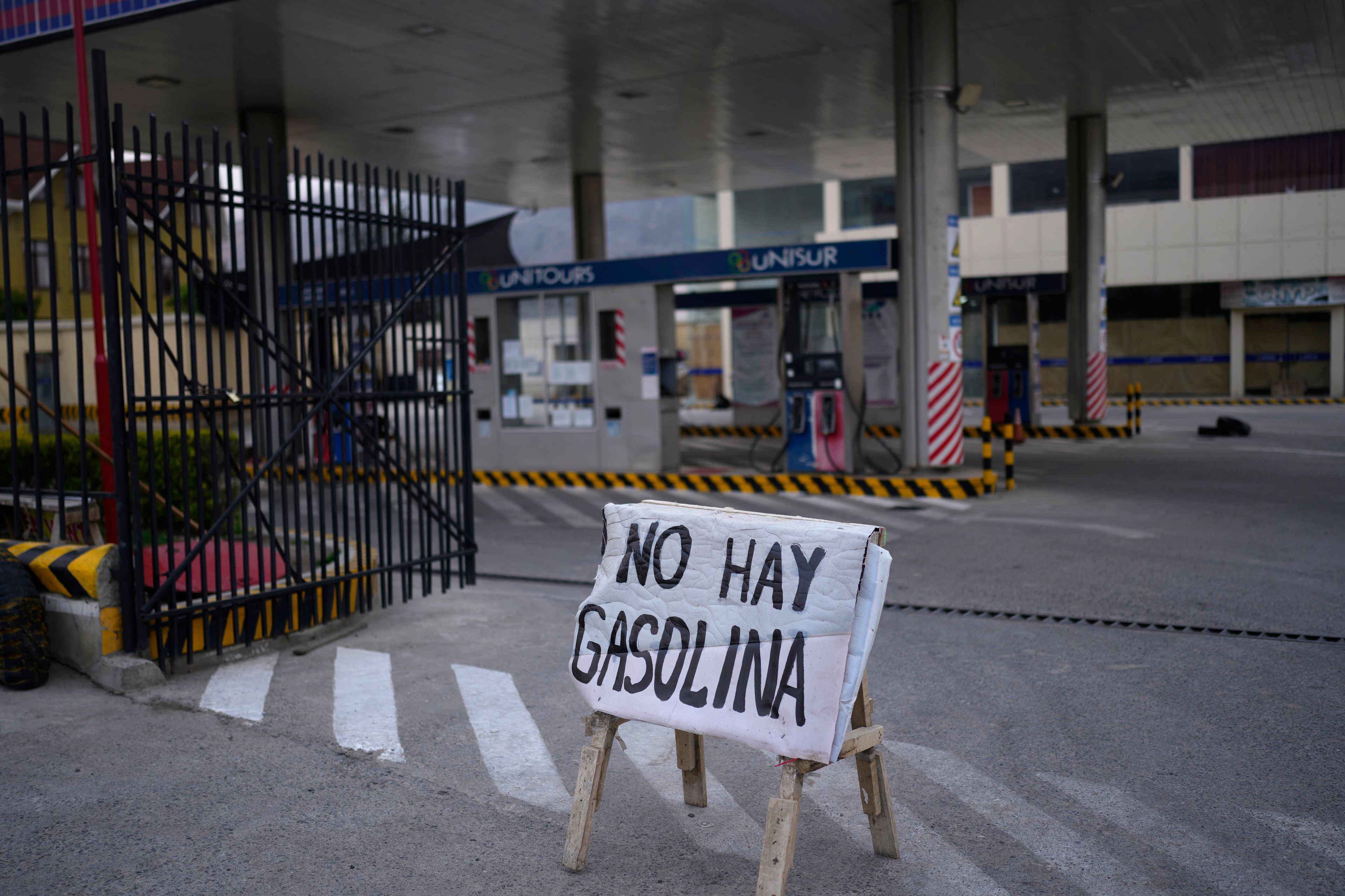 FILE - A sign alerts customers that there is no gasoline at a fuel station after five days of roadblocks by supporters of former President Evo Morales affecting the fuel and food supply, in La Paz, Bolivia, Oct. 21, 2024. (AP Photo/Juan Karita, File)