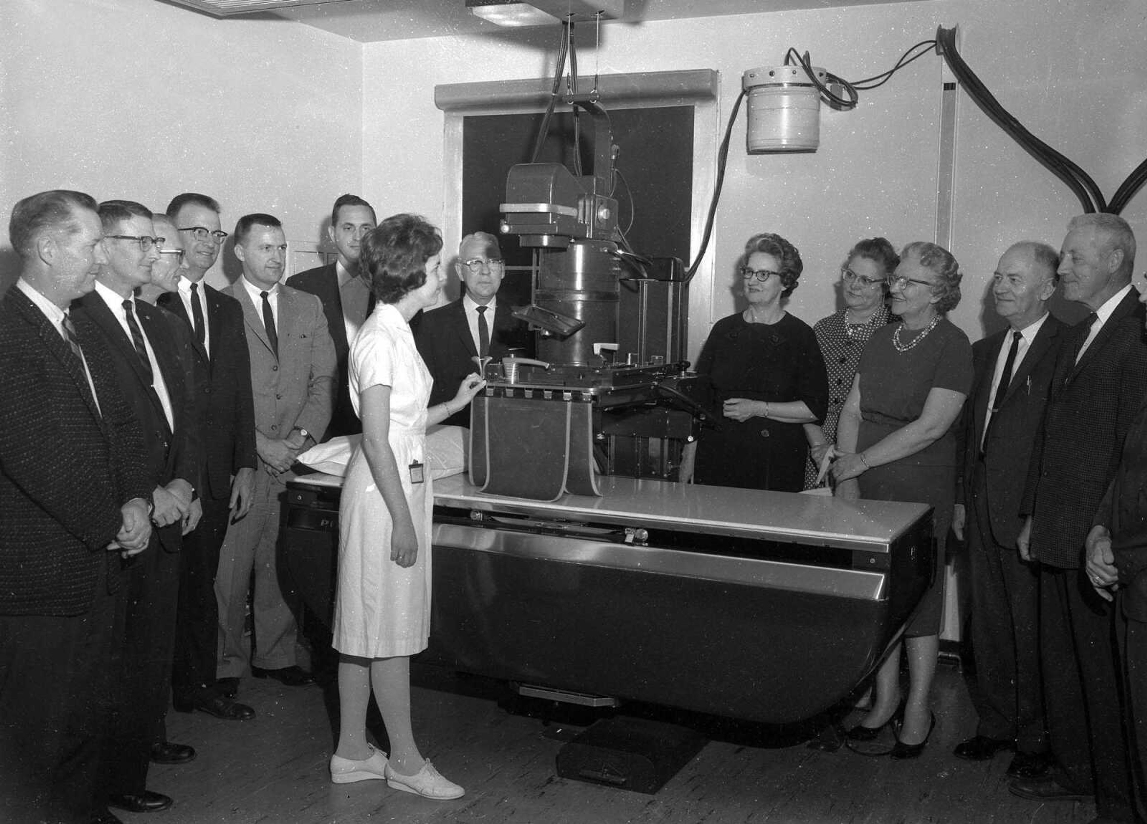 Published April 26, 1963. High school guidance counselors from southeast Missouri who attended a program on career opportunities in the medical field held at Southeast Missouri Hospital Thursday, are shown some of the hospital's X-ray equipment by Miss Renee Osborn, X-ray technician student. From left the counselors are: George Cole, Dexter; Norman Schwab, Cape Girardeau; Edgar Ailor, Cape Girardeau; Ray Sheets, Cape Girardeau; Bill Hodges, Charleston; Bill Young, Delta; Chester Masterson, Cape Girardeau; Miss Osborn; Mrs. Grace Miller, Cape Girardeau; Mrs. Verna Mae Mulkey, Cape Girardeau; Miss Mary Moore, East Prairie; Tom Cushman, Cape Girardeau; and Robert G. Aubuchon, Jackson. (G.D. Fronabarger, Southeast Missourian archive) [Bill Stone wrote: "Second from the left is Norman Schwab. Fourth from the left is Raymond Sheets. Seventh from the Left is Chester Masterson, and second from the right is Thomas Cushman. All were associated with Central High School, Mr. Sheets was principal, Mrs. Masterson and Cushman were counselors, and Mr. Schwab was a history teacher."]