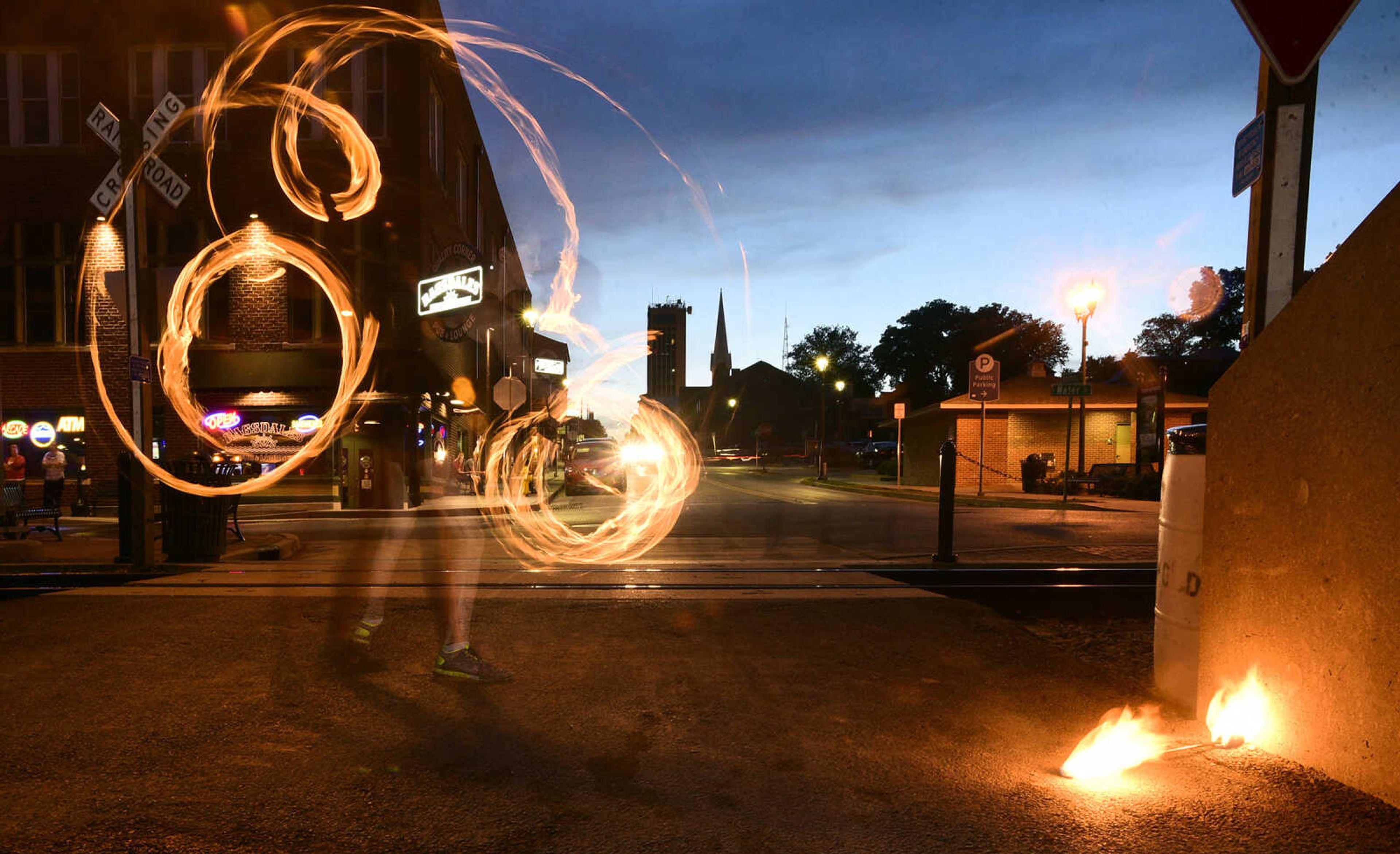 Erin Fluegge twirls flaming batons along the riverfront on Friday, June 16, 2017, in downtown Cape Girardeau.