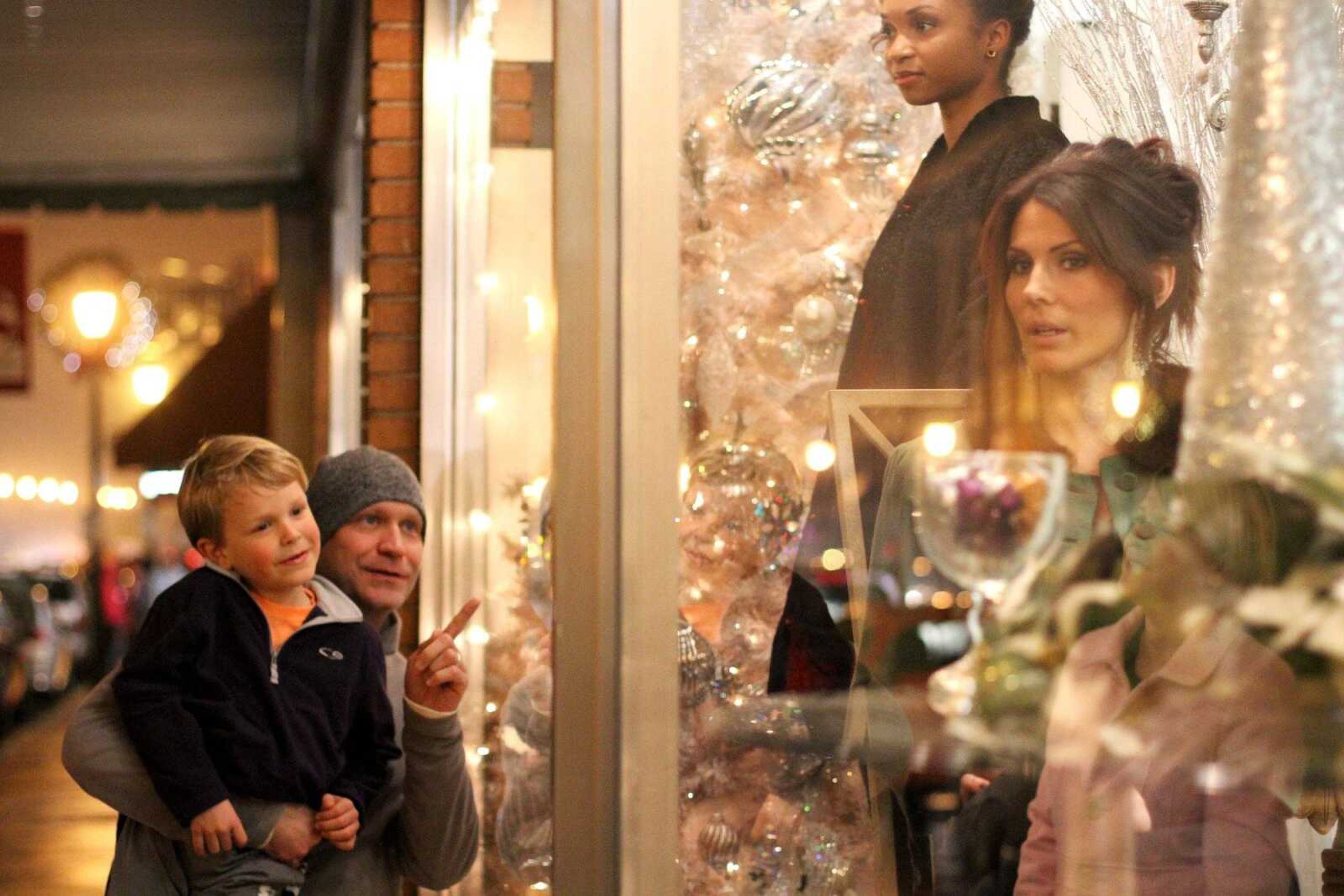 Chris Casey shows his son Ethan, 6, the live models in the windows of Pastimes Antiques during Old Town Cape's annual Downtown Christmas Open House on Dec. 5, 2014. (Glenn Landberg)