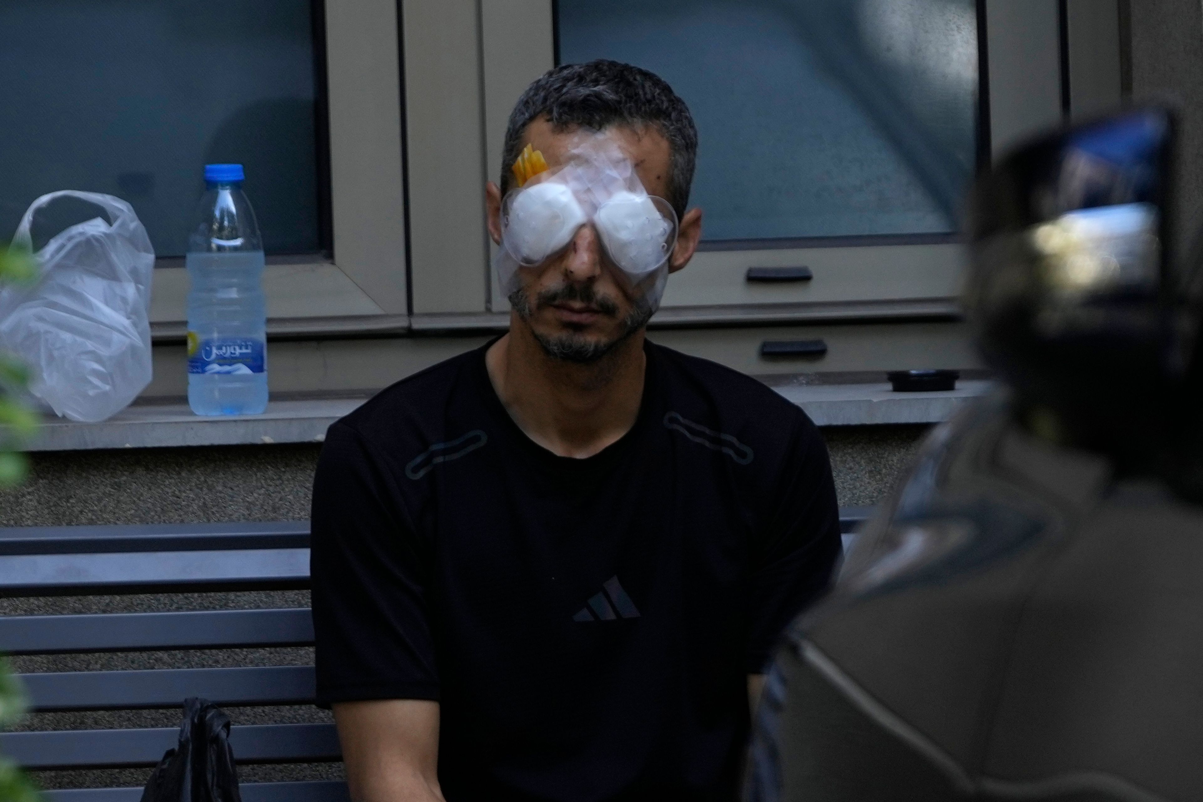 A man who was injured in the explosion of one of the handheld devices, sits outside the Eye Specialist hospital, in Beirut, Lebanon, Friday, Sept. 20, 2024. (AP Photo/Hussein Malla)