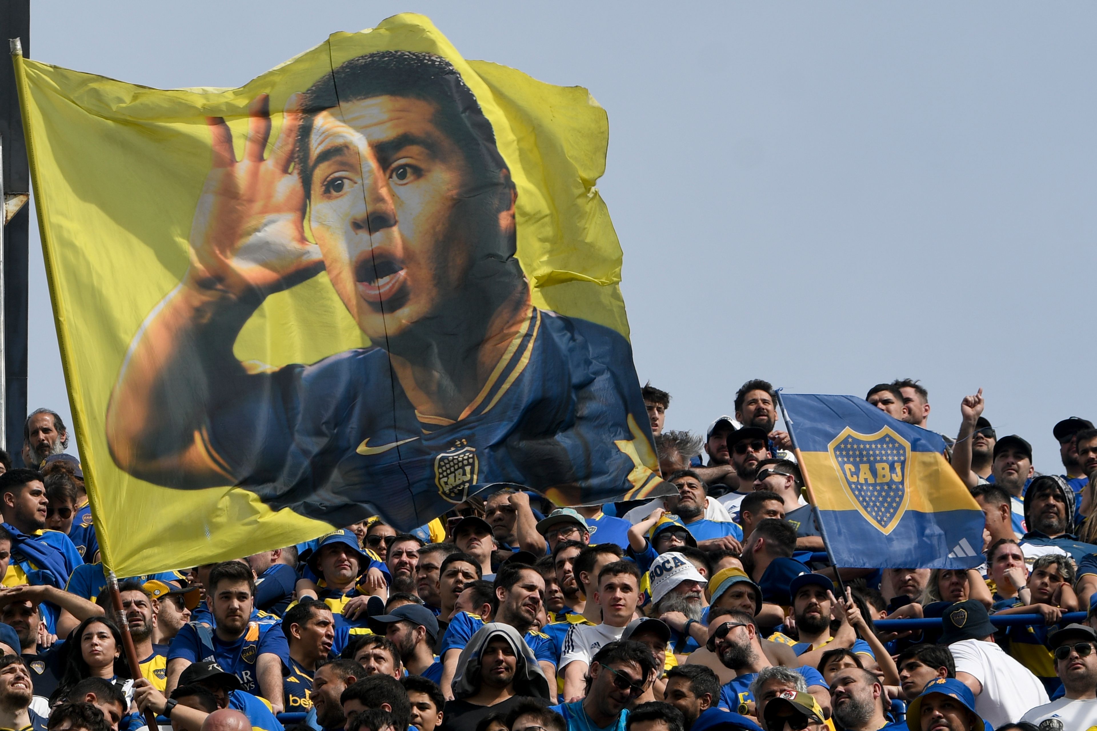 Boca Juniors fans wave a banner of Juan Roman Riquelme, soccer club president, during an Argentine league match against River Plate at La Bombonera stadium in Buenos Aires, Argentina, Sept. 21, 2024.(AP Photo/Gustavo Garello)