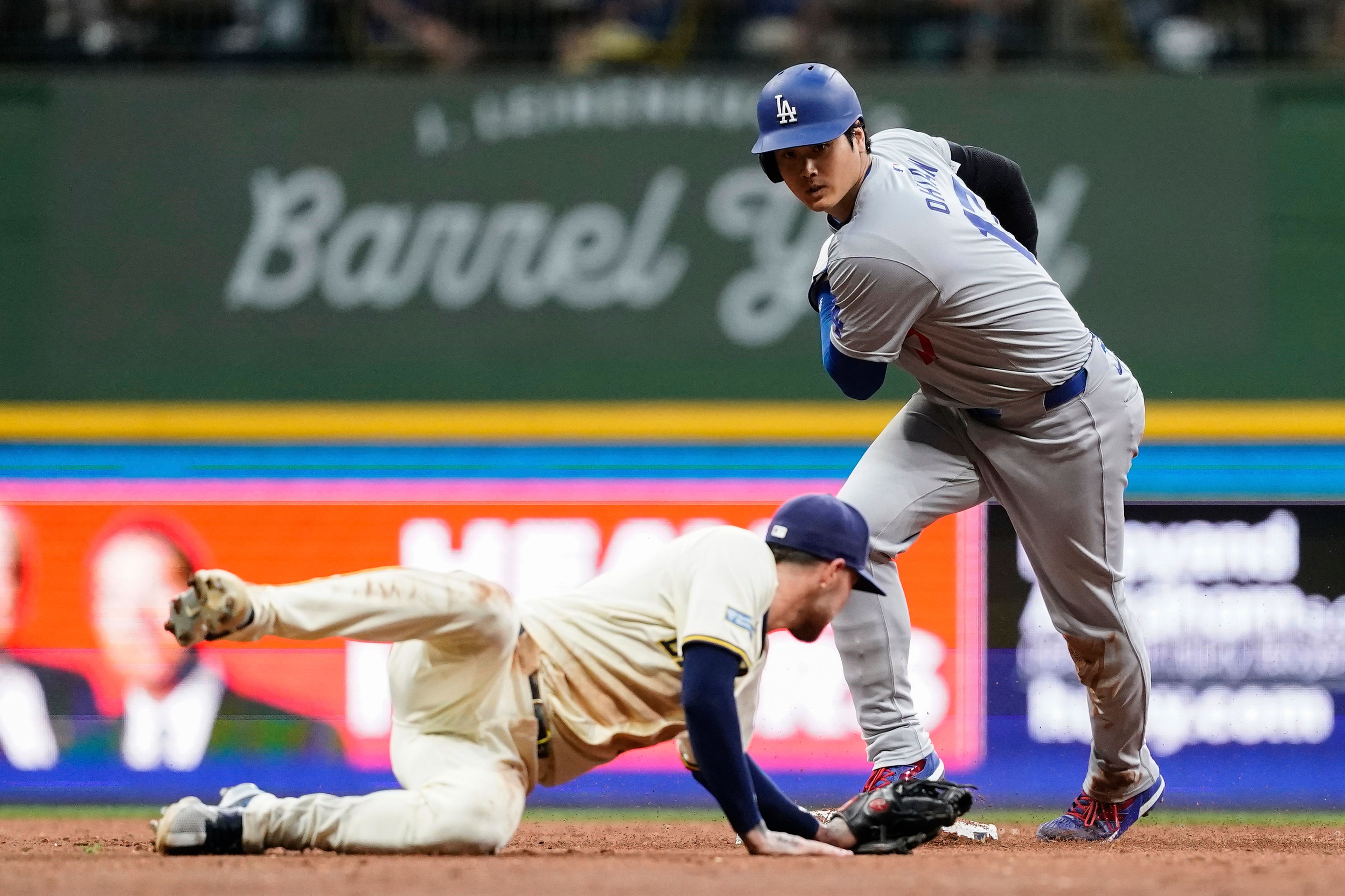 Los Angeles Dodgers' Shohei Ohtani, right, steals second base past Milwaukee Brewers' Brice Turang during the second inning of a baseball game Wednesday, Aug. 14, 2024, in Milwaukee. (AP Photo/Aaron Gash)