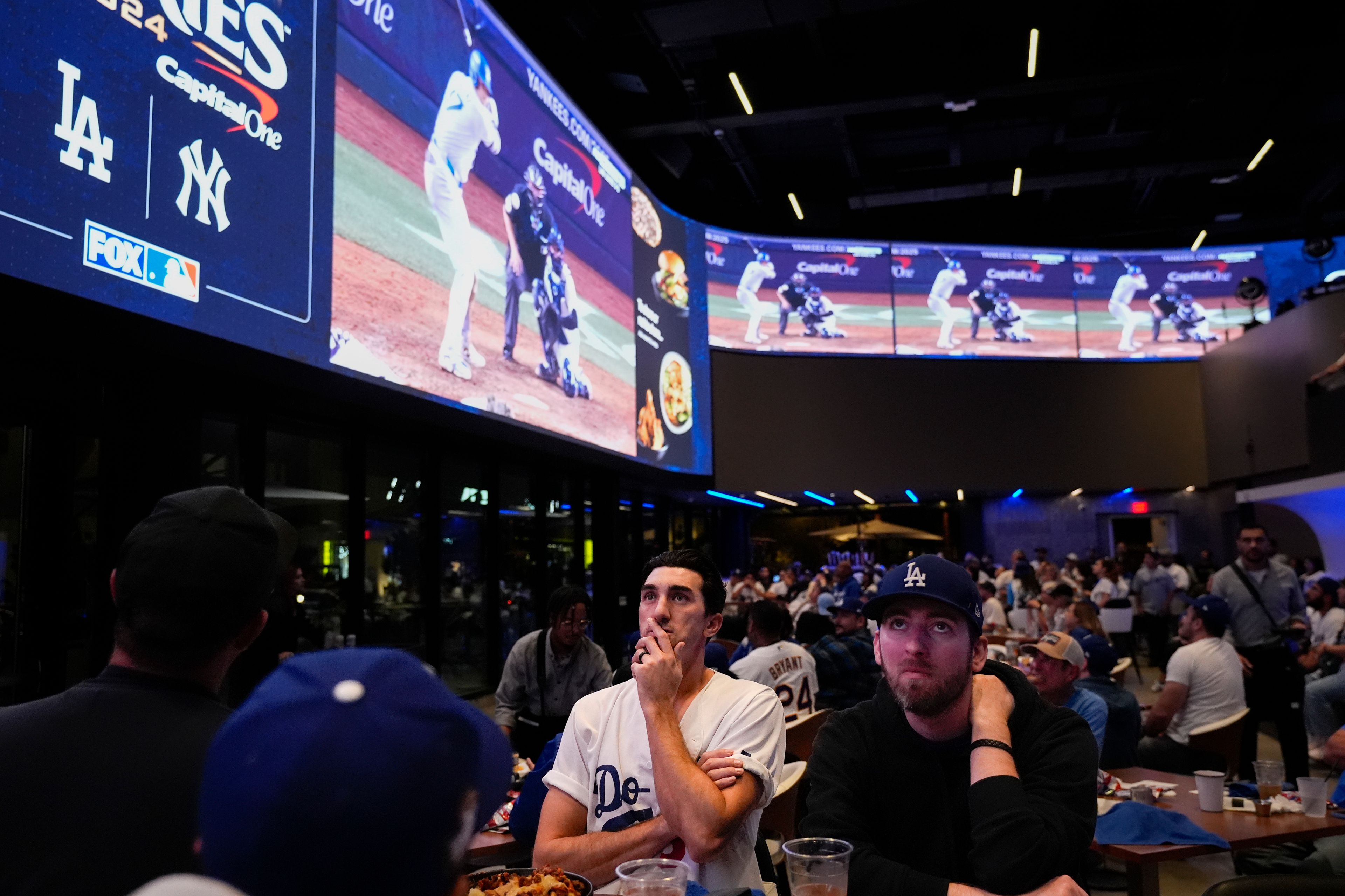 Fans watch a broadcast of Game 4 of the baseball World Series between the Los Angeles Dodgers and the New York Yankees at Cosm in Inglewood, Calif., Tuesday, Oct. 29, 2024. (AP Photo/Jae C. Hong)