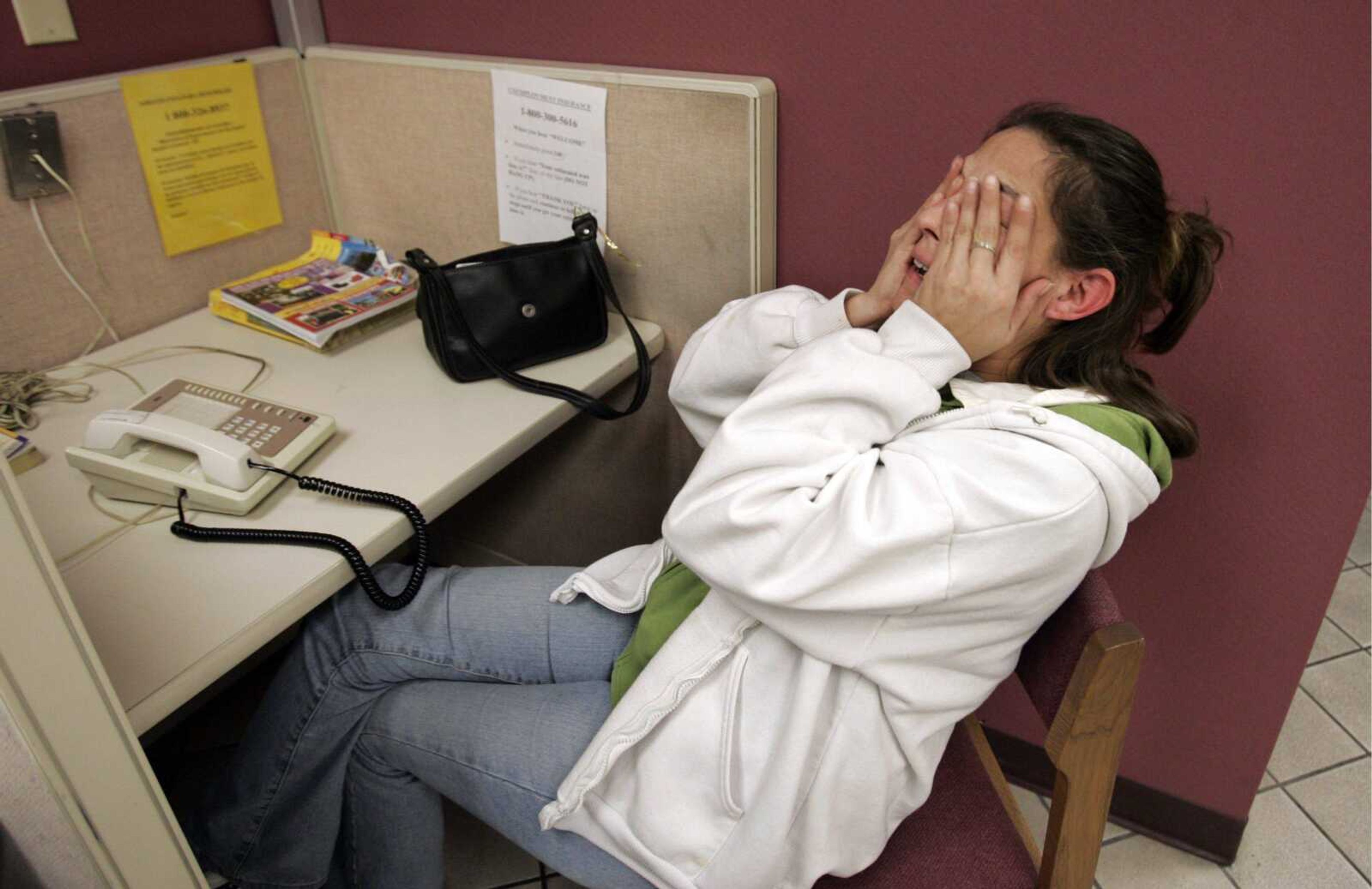 Unemployed Tracy Nikitas looked emotional Wednesday as she gave up trying to contact employment officials over the phone at the California Employment Development Department in San Jose, Calif. (PAUL SAKUMA ~ Associated Press)