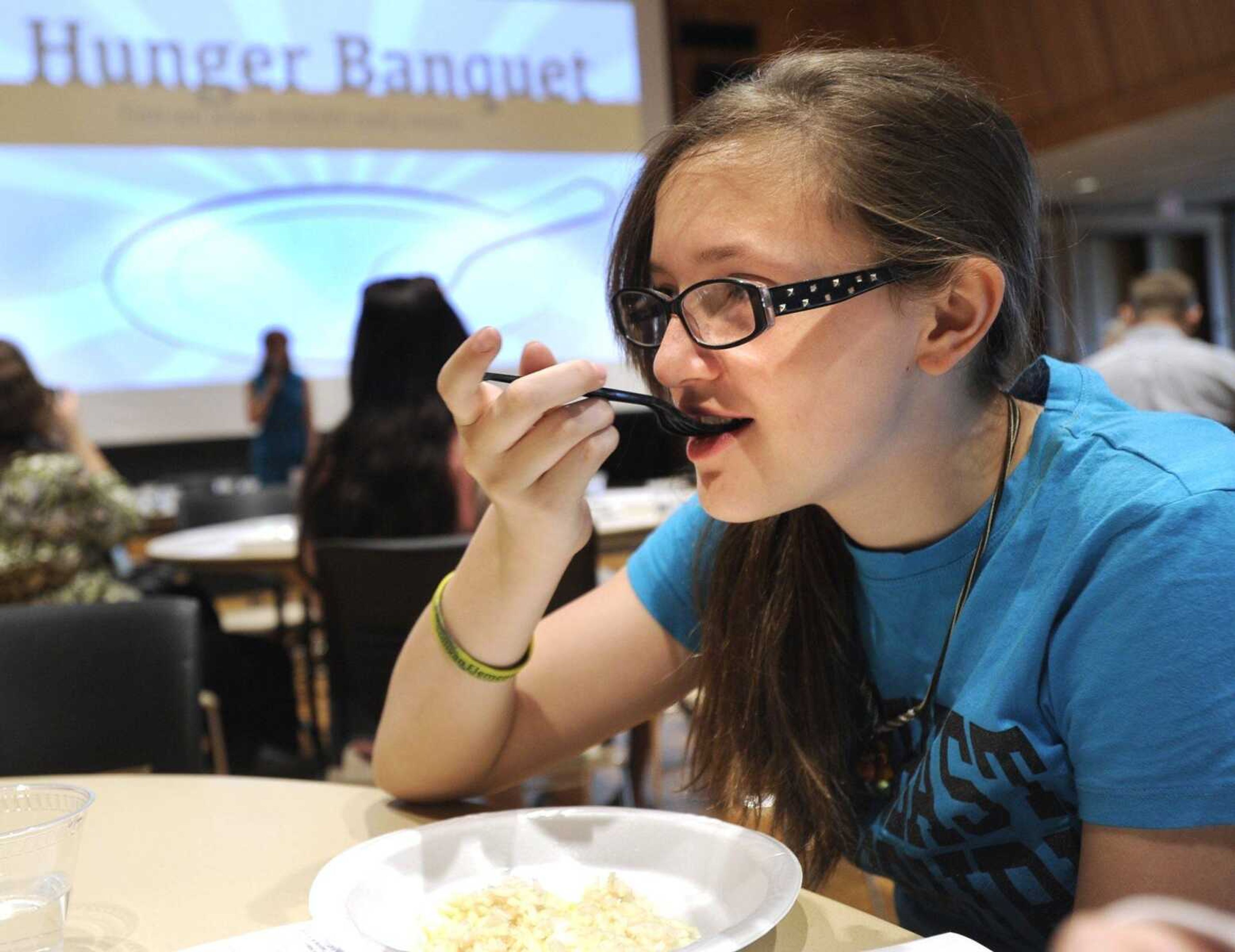 Natalie Beebe has a meal of rice and water, as she identifies with one-half the world's population with low income, during the Hunger Banquet Sunday, April 12, 2015 at the University Center. (Fred Lynch)