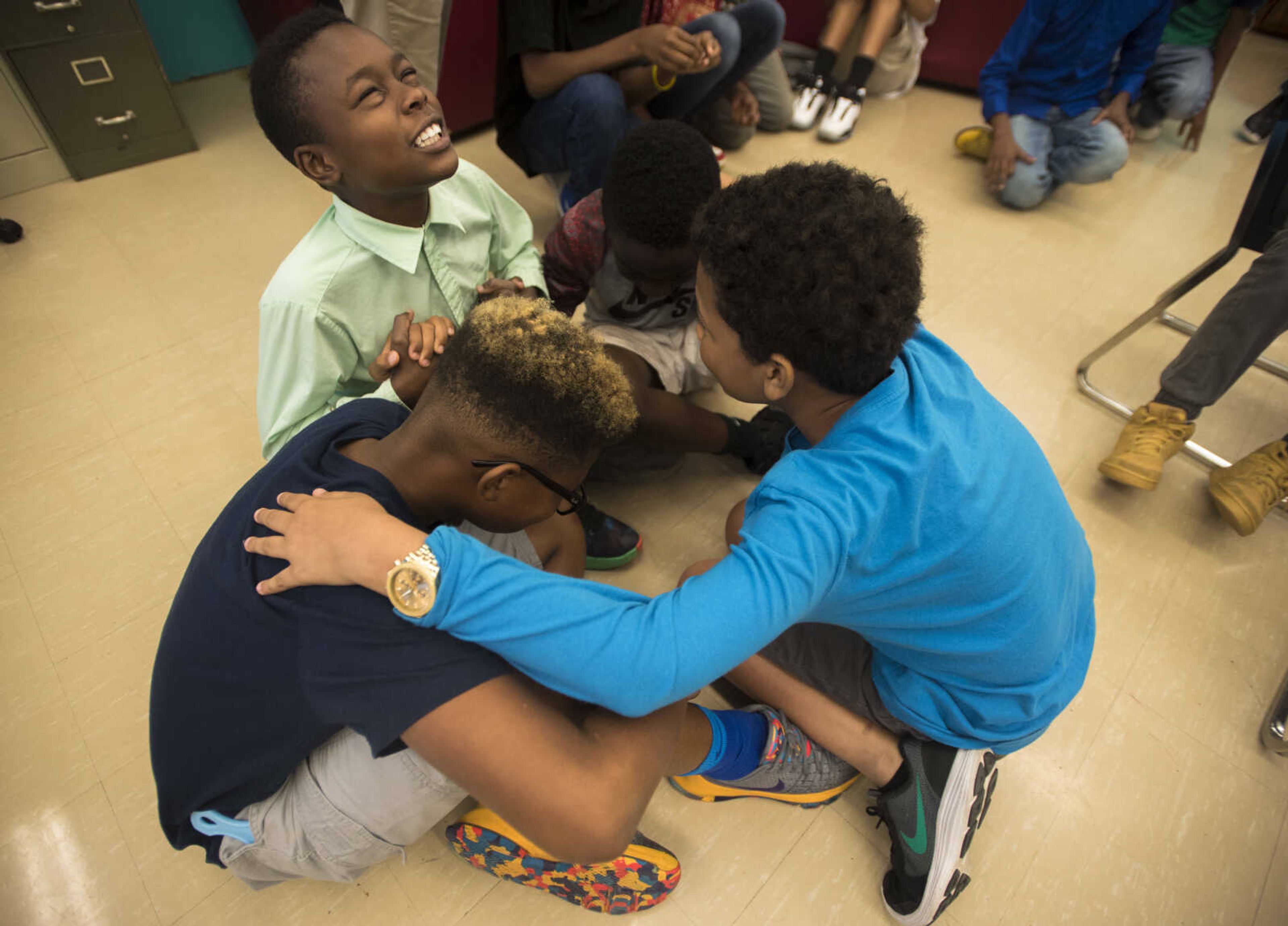 A member of the Honorable Young Men's Club leads his team in prayer before they attempt to form a "human table" Sept. 19, 2017 during a team building exercise at Central Middle School in Cape Girardeau.