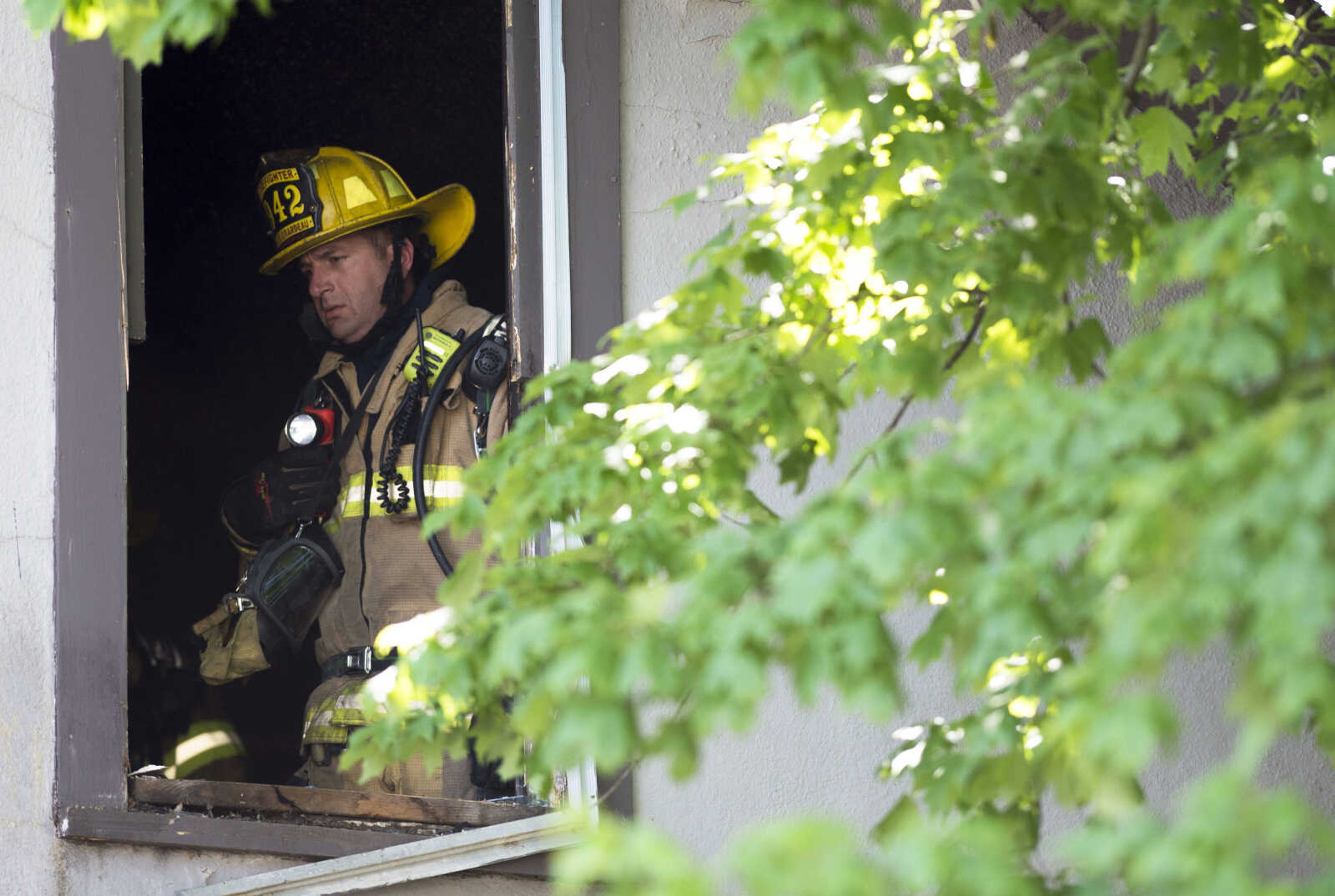 Cape Girardeau firefighter Drew Goodale investigates the upper level of 40 North Henderson Ave. after a structure fire Monday, May 11, 2020, at in Cape Girardeau.