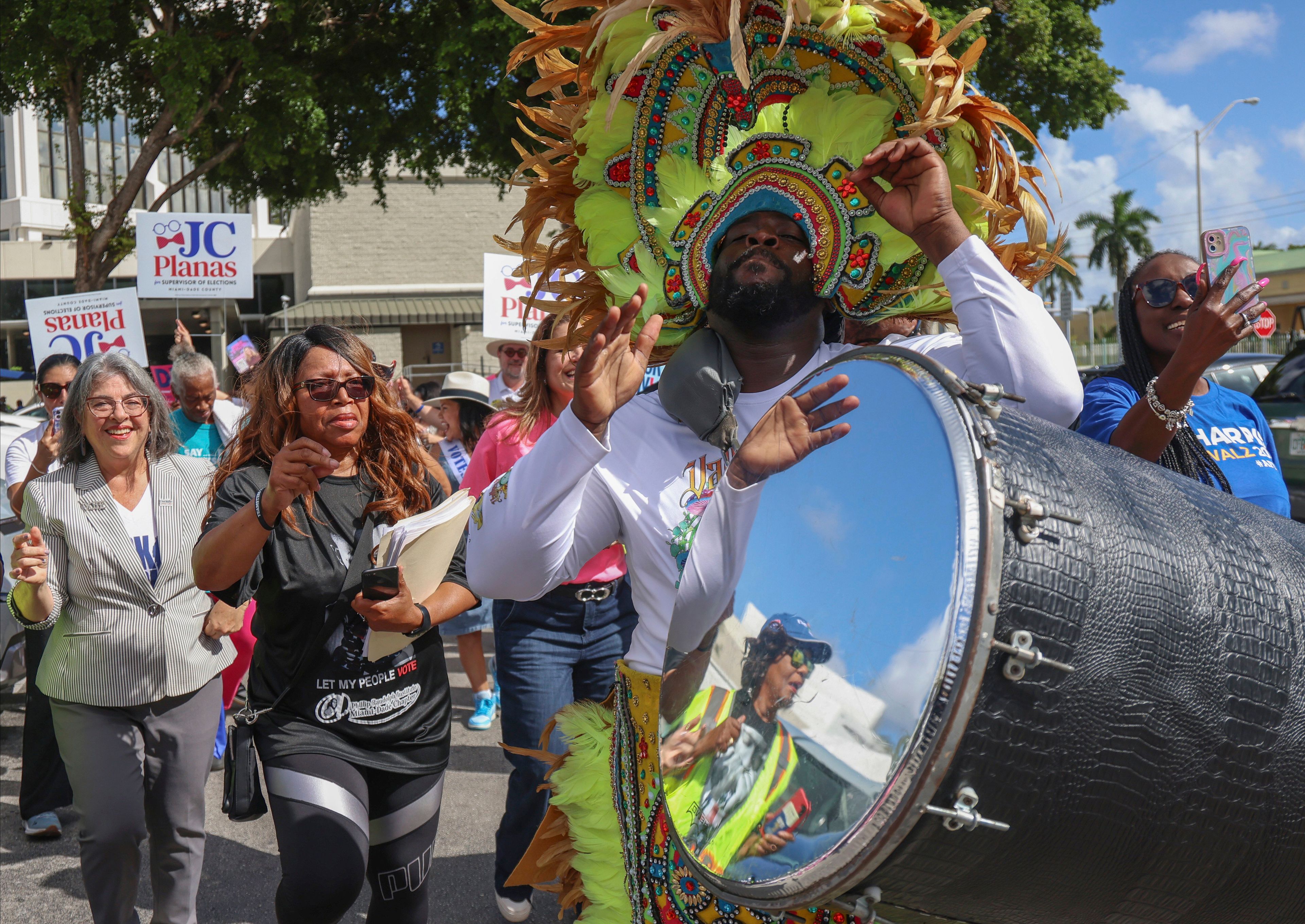 Democratic candidates, Mayor Daniella Levine Cava, left, and unincorporated Miami-Dade voters dance to the sounds of the Bahamian Junkanoo band during a festive visit to the polls at the Joseph Caleb Center during the "Souls to the Polls" event on the last day of early voting Sunday, Nov. 3, 2024, in Miami. (Carl Juste/Miami Herald via AP)