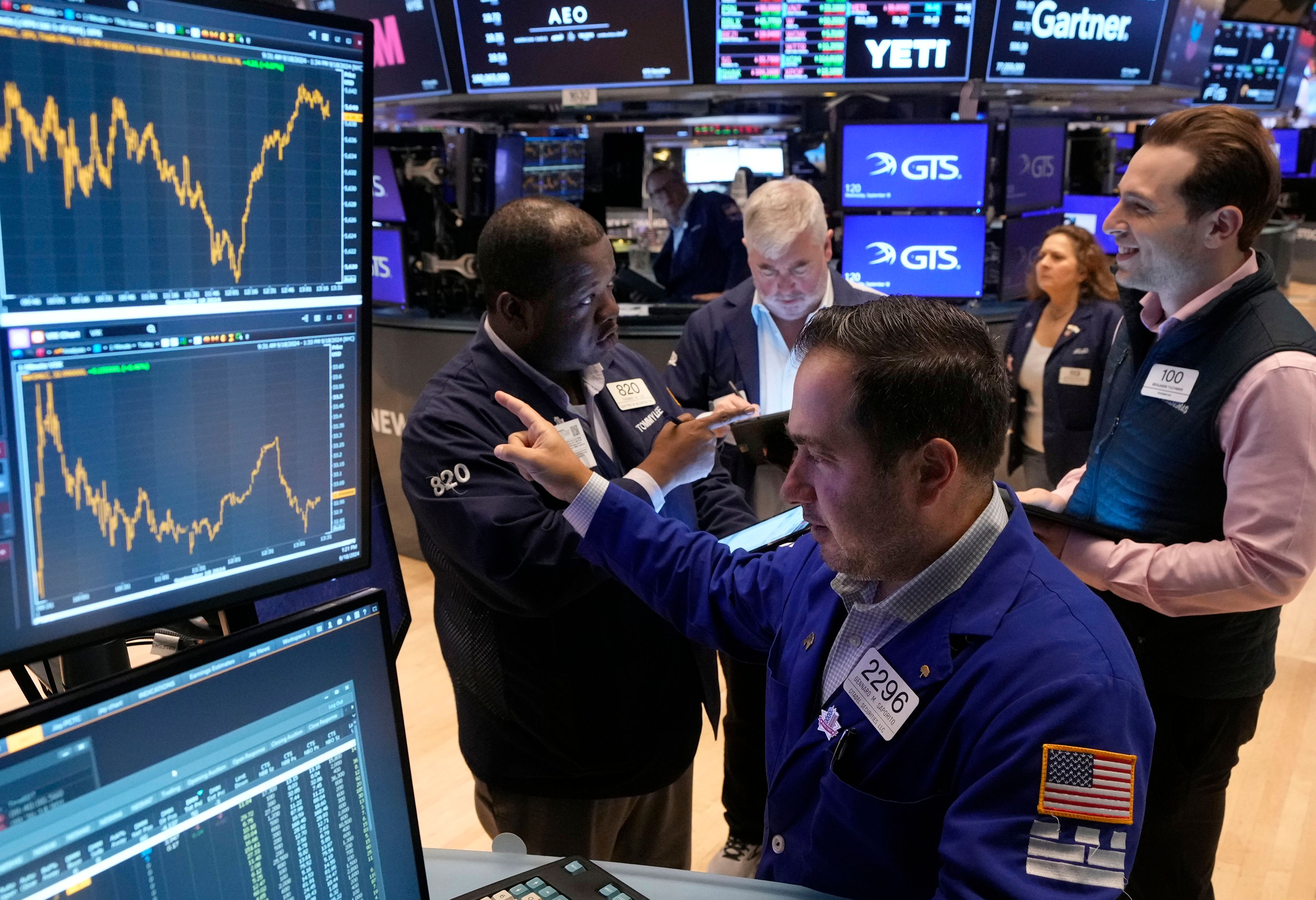 Specialist Genaro Saporito, foreground, works with traders at his post on the floor of the New York Stock Exchange, Wednesday, Sept. 18, 2024. (AP Photo/Richard Drew)