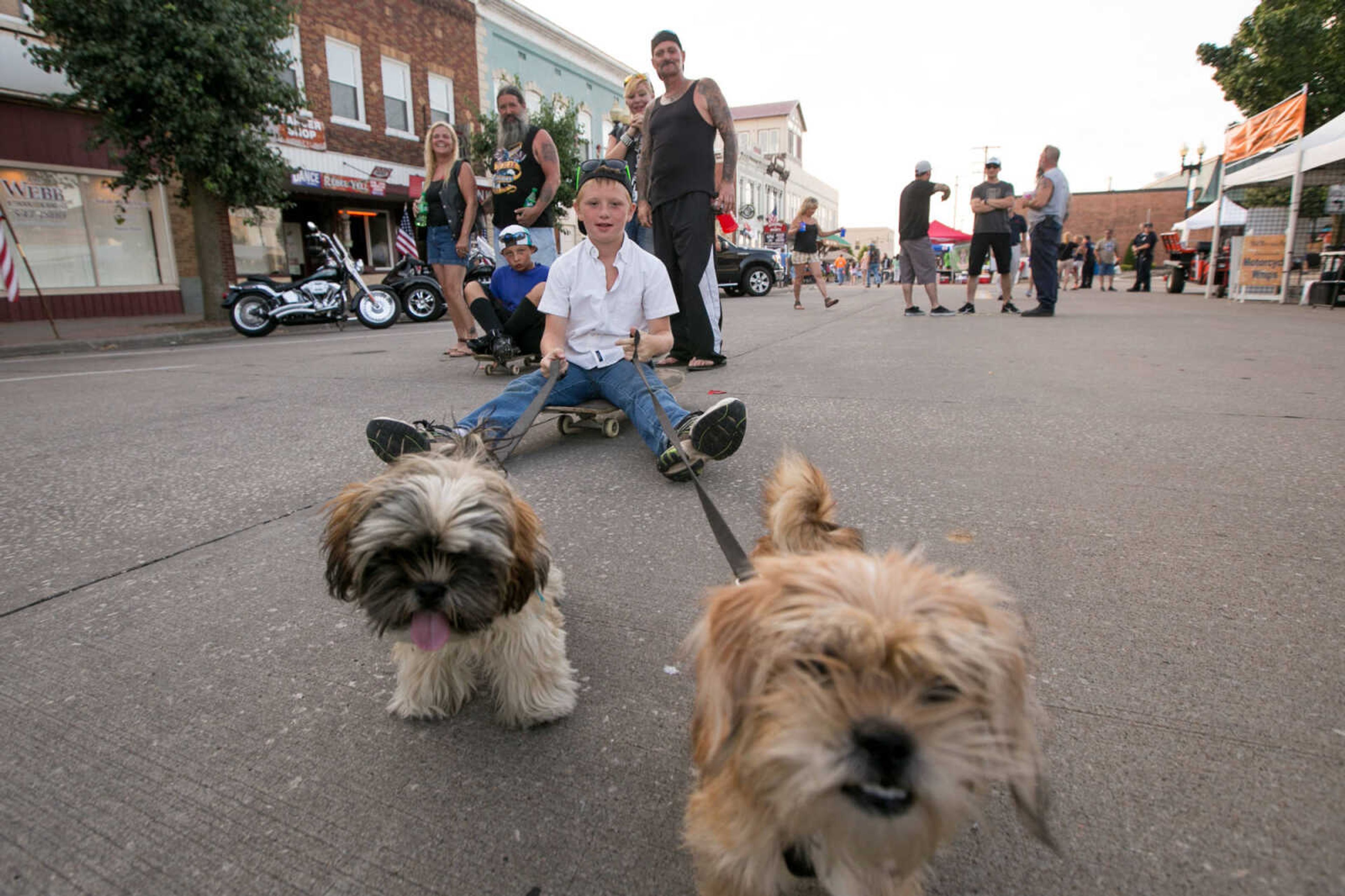 GLENN LANDBERG ~ glandberg@semissourian.com

Joseph Reynolds is pulled along on his skateboard by Chewy and Jack during the 4th Annual Bikers on the Square Friday, June 17, 2016 in Perryville, Missouri.