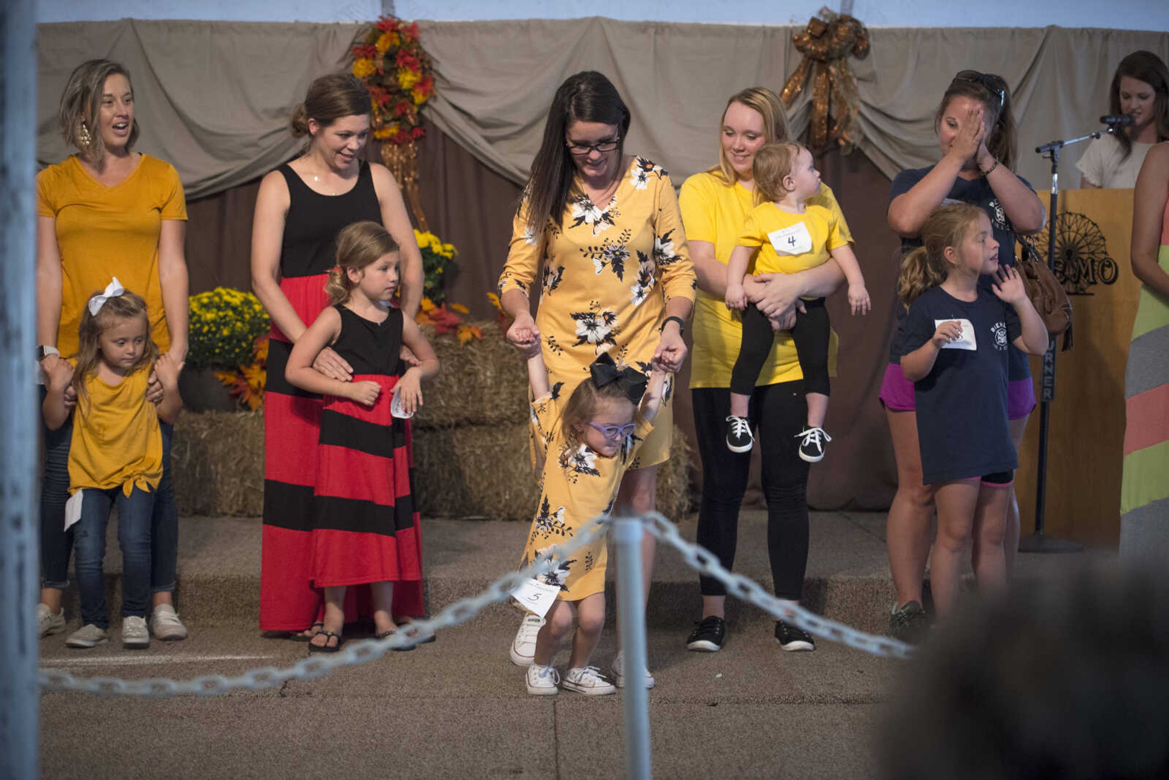 Niomie Zoellner holds her three-year-old daughter Kylee's hands as she leaps forward after being named third place winners in the Mother Daughter Lookalike contest Sept. 9, 2019, at the SEMO District Fair in Cape Girardeau.