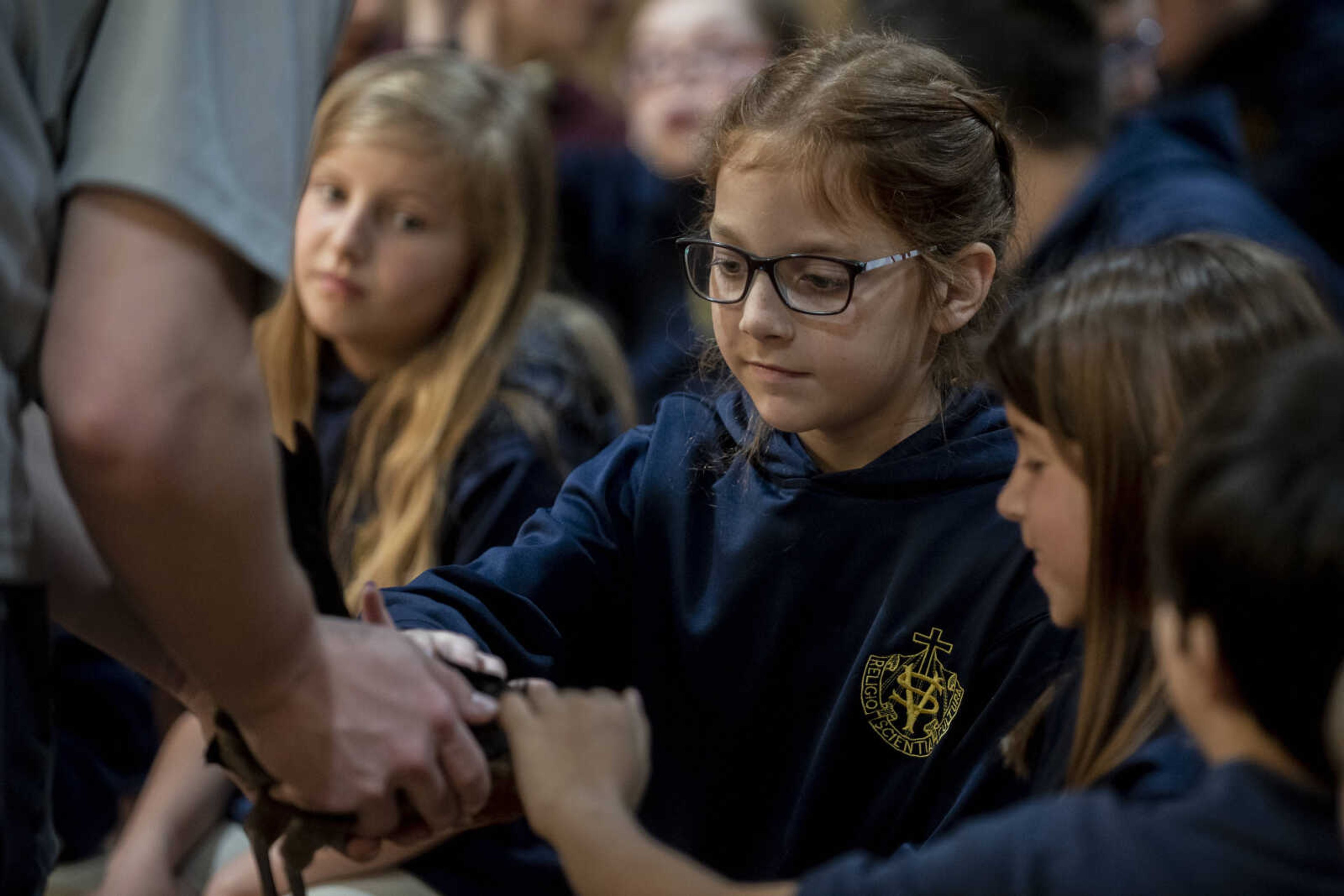 Kinley Boxdorfer, 9, pets a chicken, held by Steven Peters, with classmate Morgan Schnurbusch, 9, during the 24th annual Farm Day sponsored by the Southeast Missouri Cattlemen's Association at Flickerwood Arena Wednesday, April 24, 2019, in Jackson. Over 800 students attended Farm Day and learned about a variety of farm-related topics from forestry to soil conservation, as well as farm animals and honey bees.