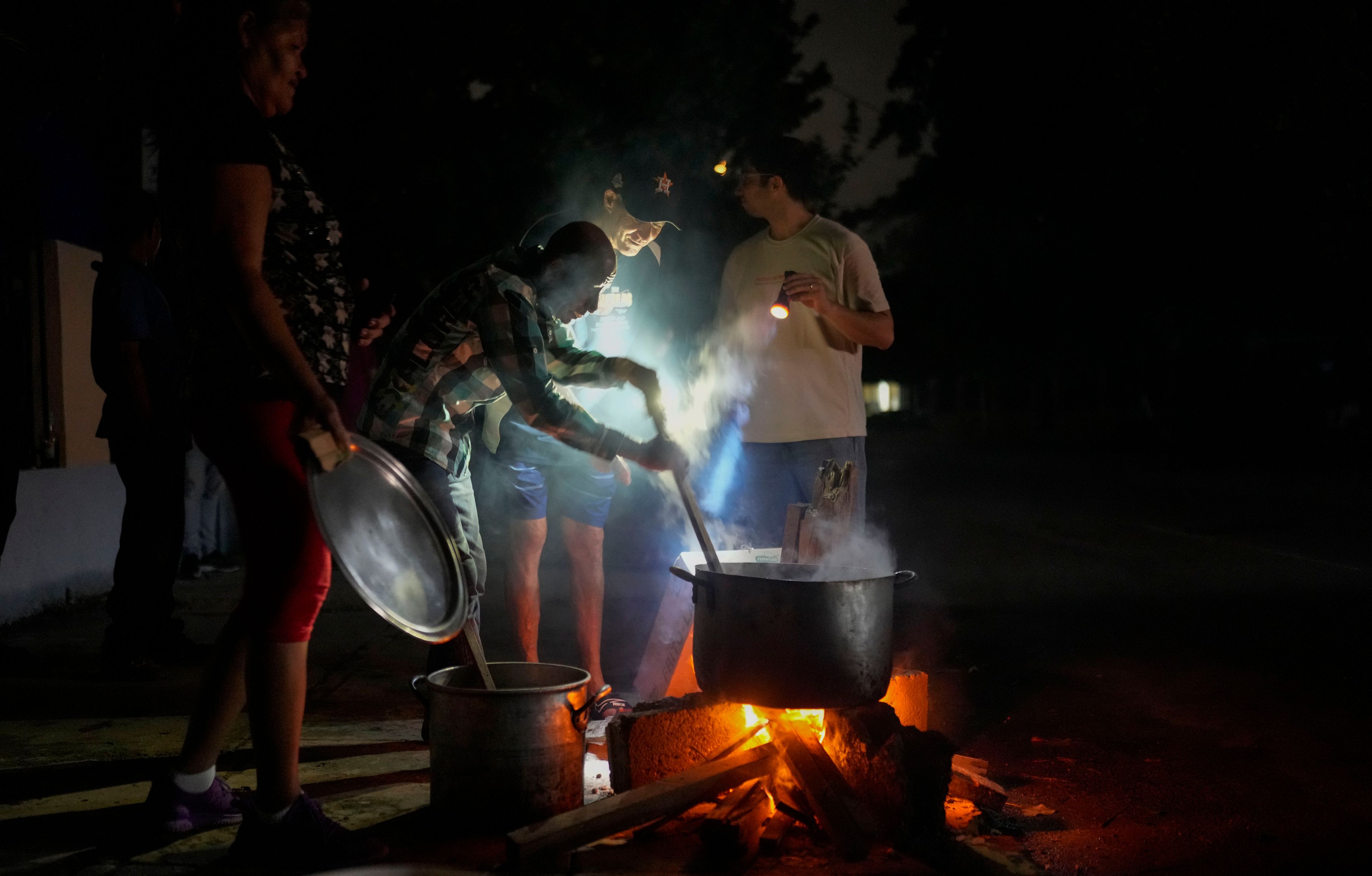 FILE - Cuba’s at one of its lowest points since the 1959 revolution, with nationwide scarcity fueling massive emigration and nationwide blackouts that forced people to cook soup over an open fire in Havana after the failure of a major power plant, on Oct. 19, 2024. (AP Photo/Ramon Espinosa, File)