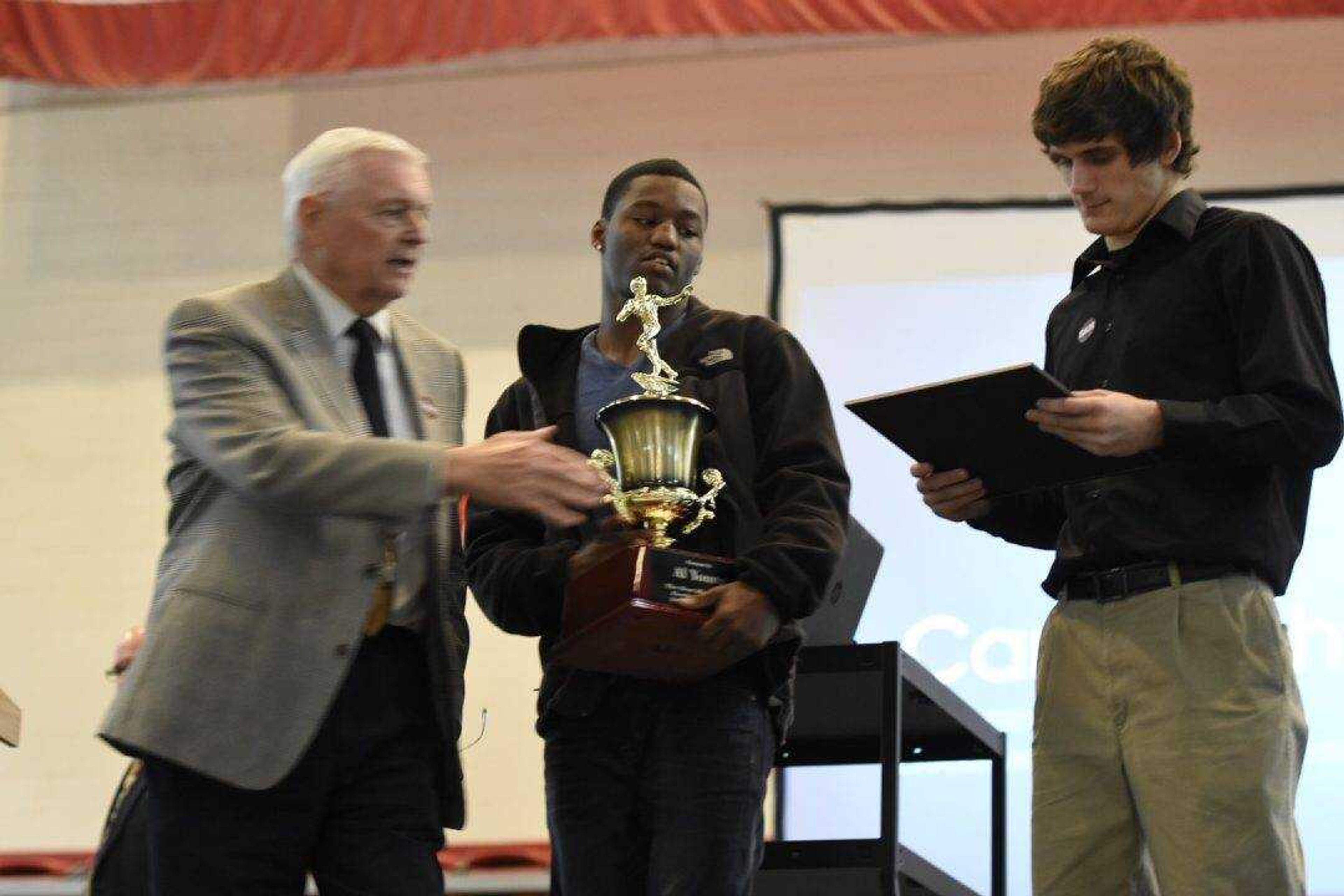 Al Young receives the Carr Trophy from John Muench of the Carr Trophy committee on Wednesday in Poplar Bluff, Missouri. (Brian Rosener ~ Daily American Republic)