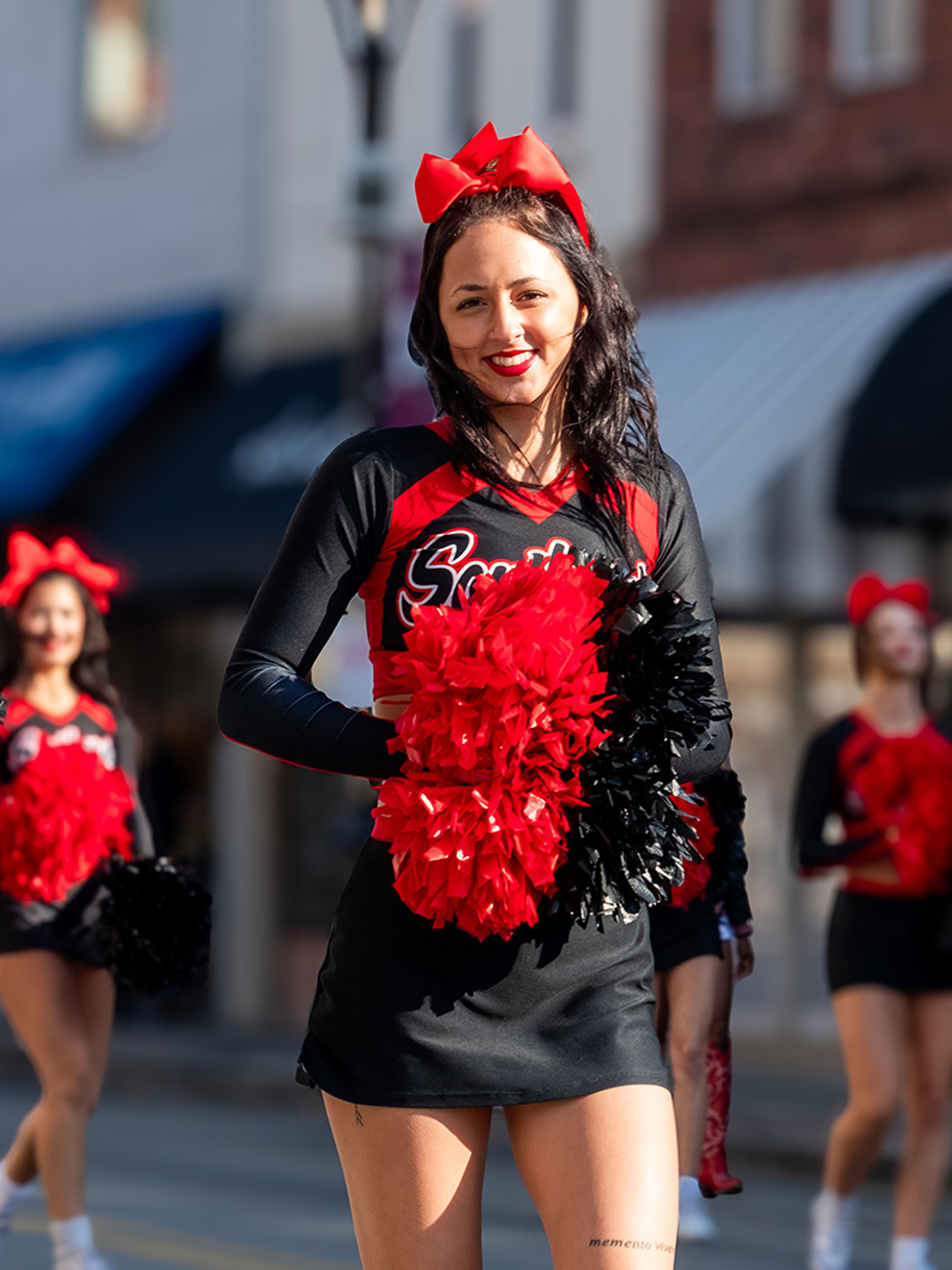 SEMO cheerleader Lillian Yates from Lake St. Louis smiles as she twirls her pom-poms.
