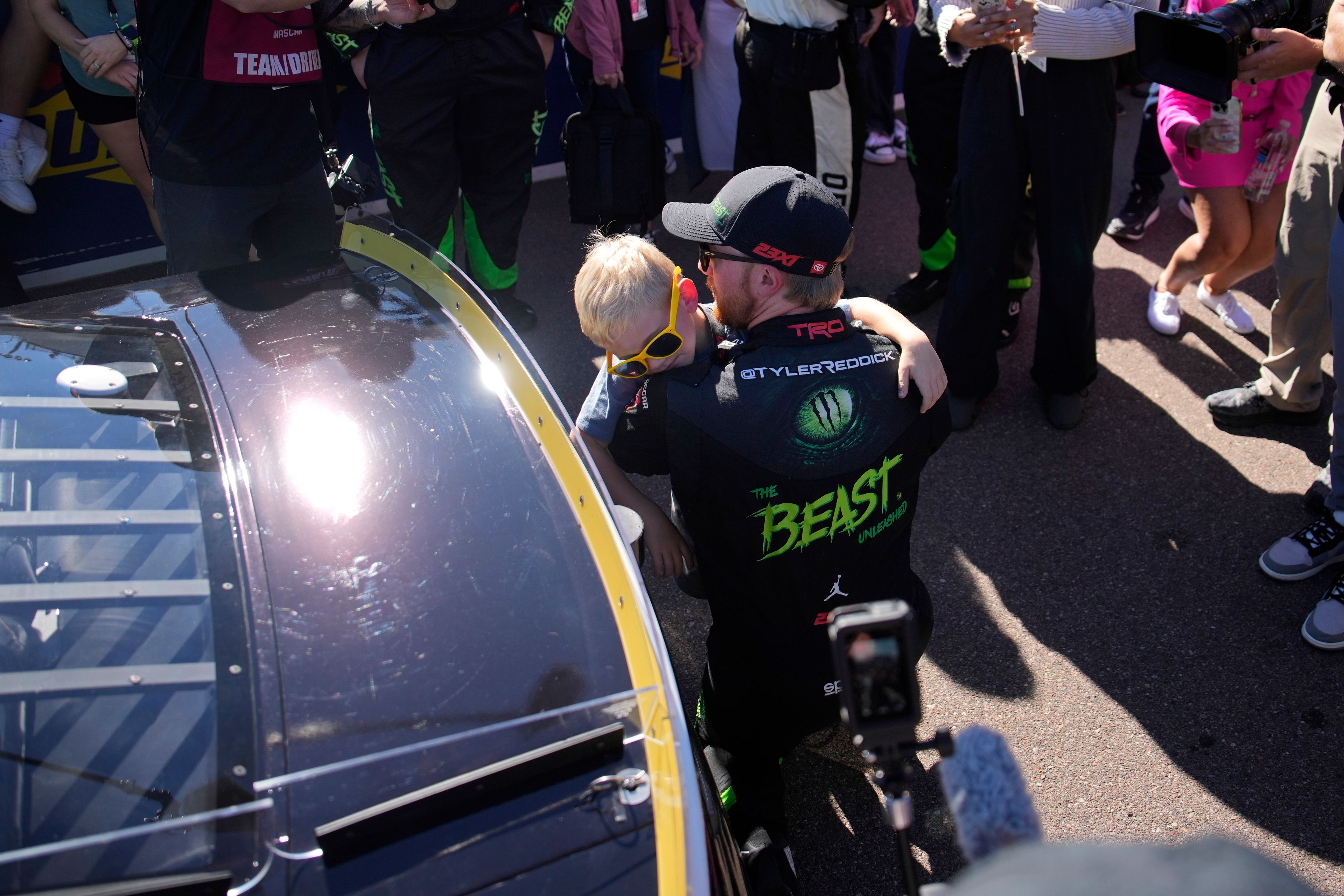 Tyler Reddick embraces son Beau before a NASCAR Cup Series Championship auto race at Phoenix Raceway, Sunday, Nov. 10, 2024, in Avondale, Ariz. (AP Photo/John Locher)