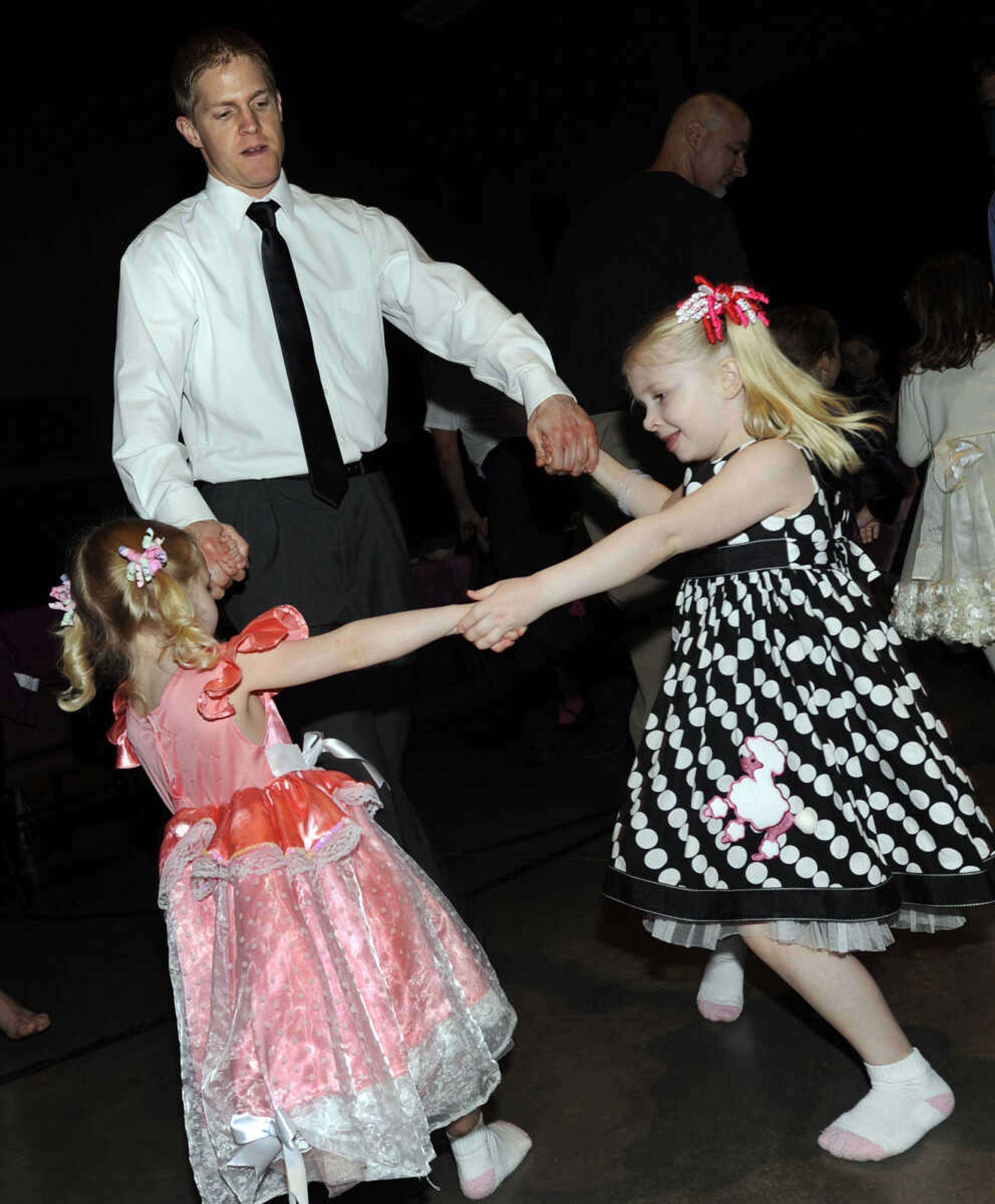 Megan and Lauren dance with their father, Daryl, at the Me and My Guy Dance.