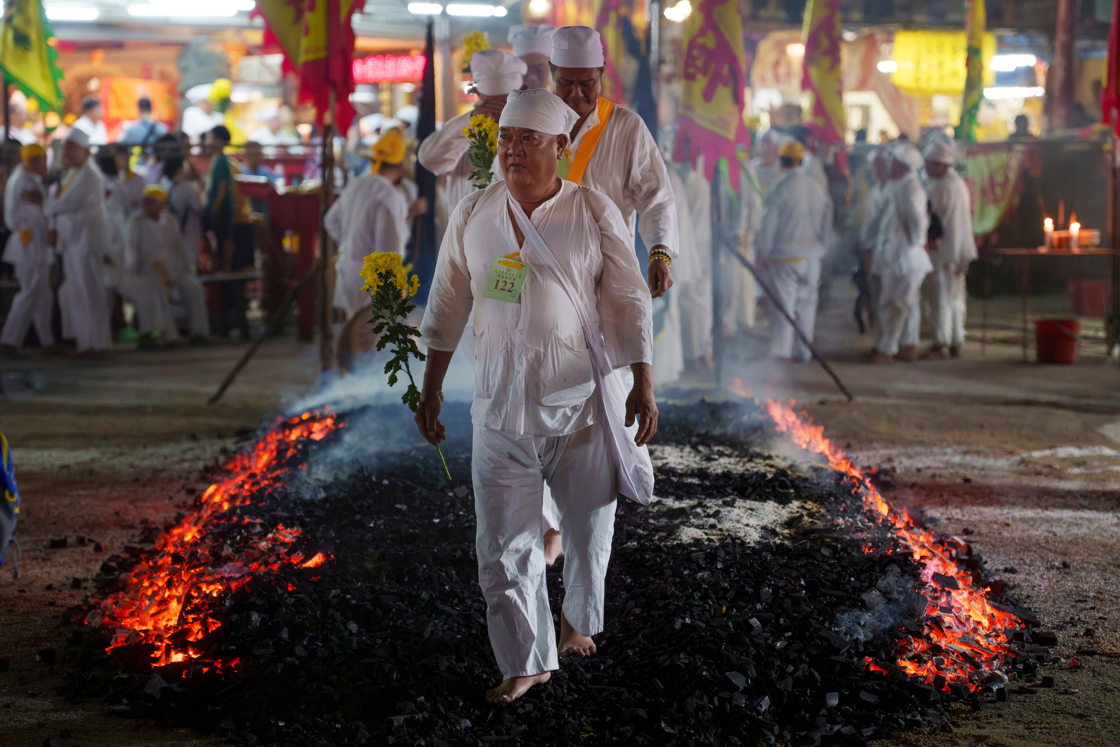 Malaysian Chinese devotees walk barefoot over burning coals during the Nine Emperor Gods festival at a temple in Kuala Lumpur, Malaysia, Friday, Oct. 11, 2024. (AP Photo/Vincent Thian)