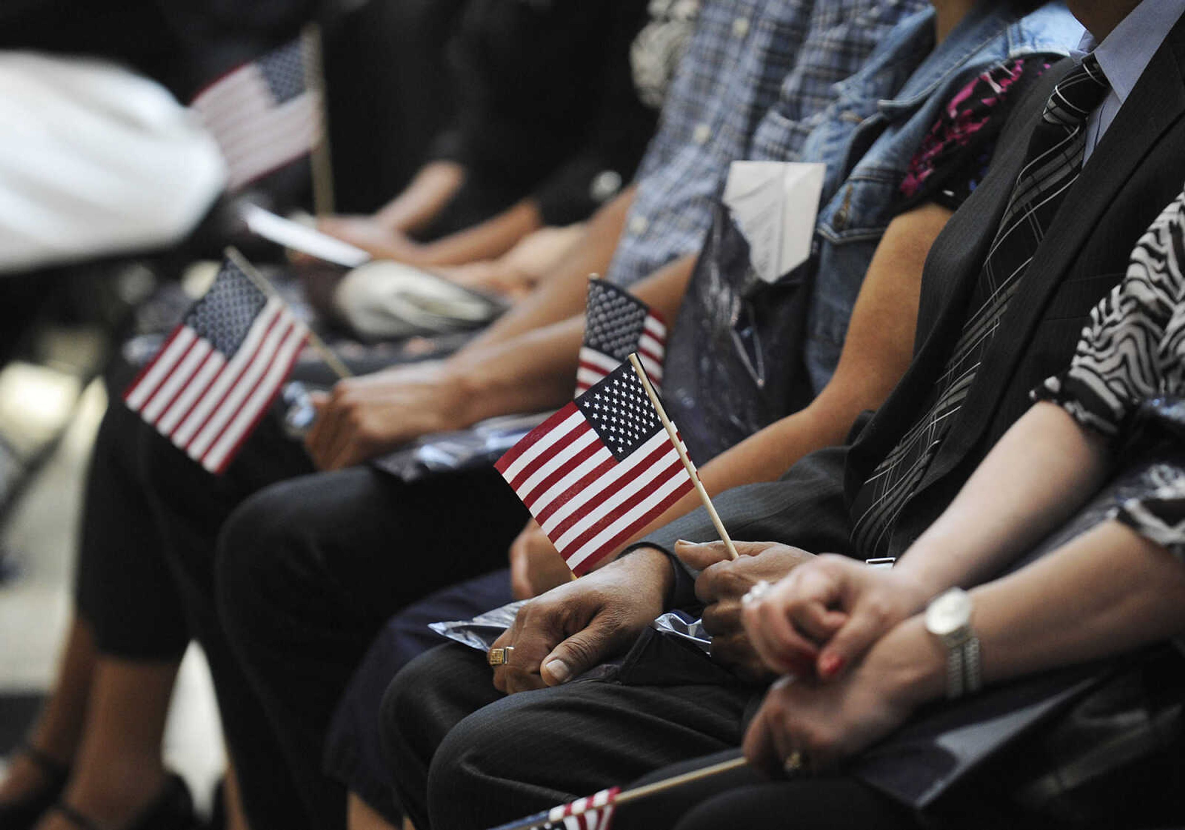 Immigrants hold small American flags during a naturalization ceremony Wednesday, May 1, at the Rush H. Limbaugh Sr. U.S. Courthouse in Cape Girardeau. U.S. District Court Judge Stephen N. Limbaugh Jr. administered the Oath of Allegiance to 29 people from 11 countries, making them U.S. citizens, during the ceremony.