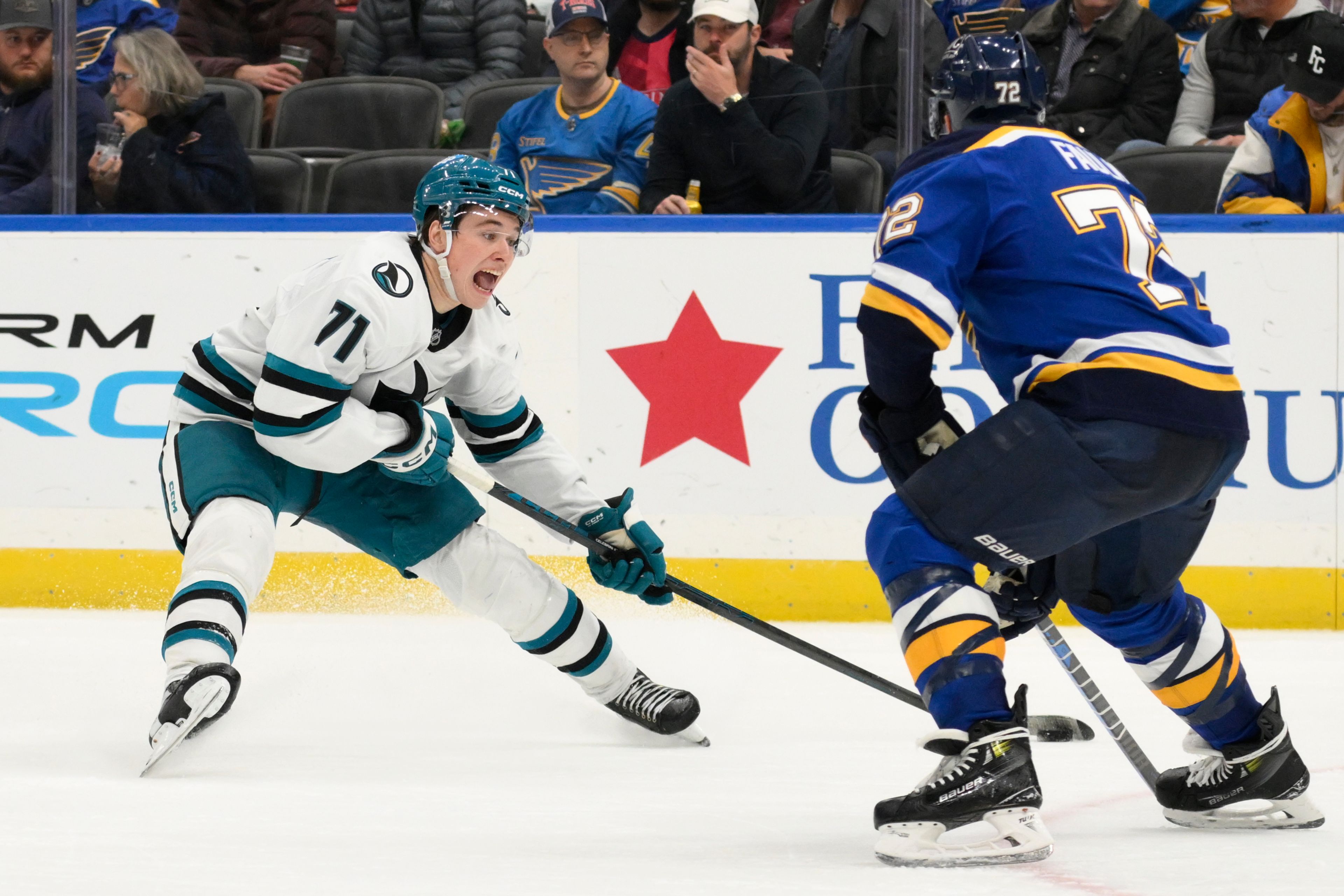 San Jose Sharks center Macklin Celebrini, left, controls the puck against St. Louis Blues defenseman Justin Faulk, right, during the third period of an NHL hockey game Thursday, Nov. 21, 2024, in St. Louis. (AP Photo/Jeff Le)