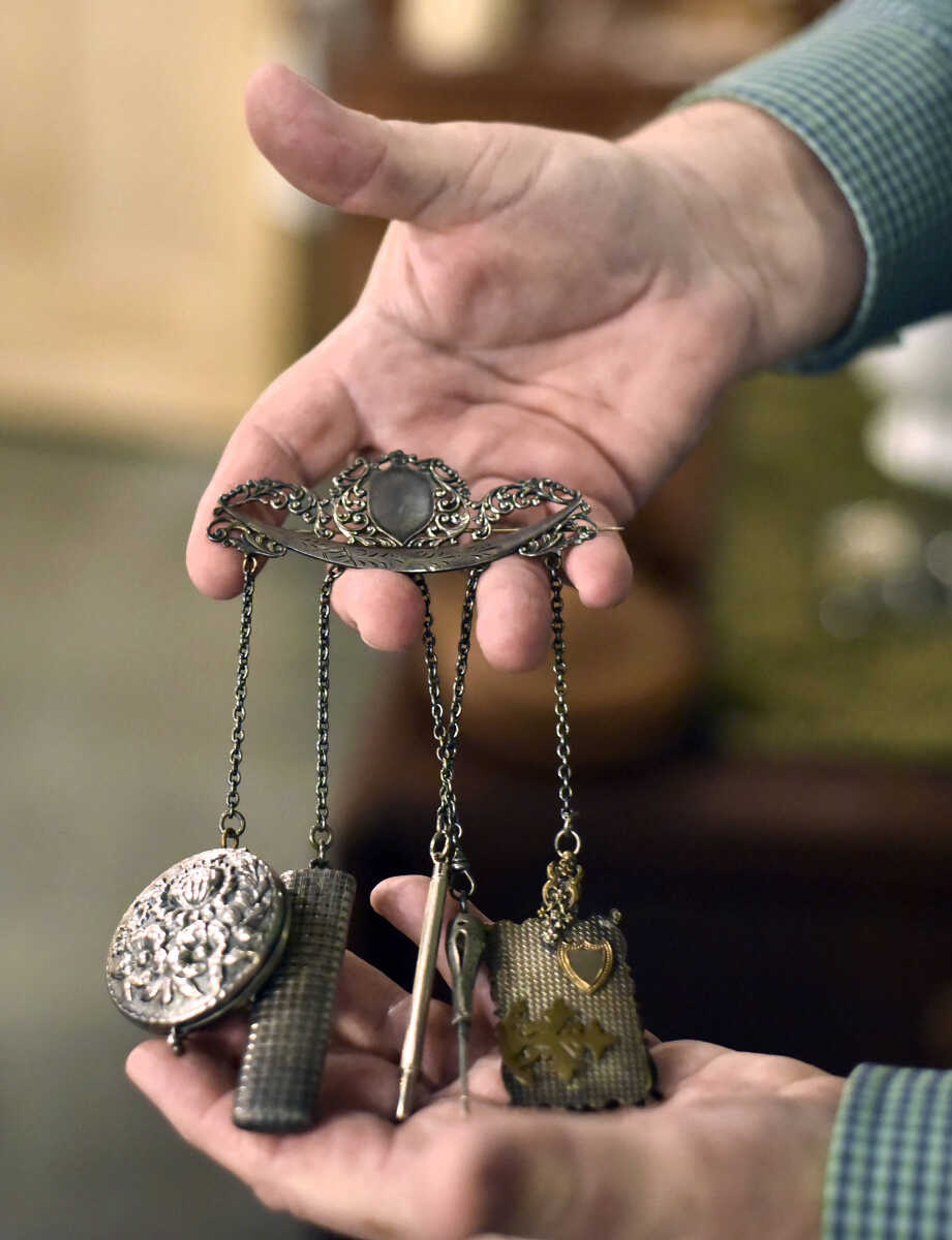 Harlan Smothers holds a chatelaine inside Fat Chance General Store in Cape Girardeau County.