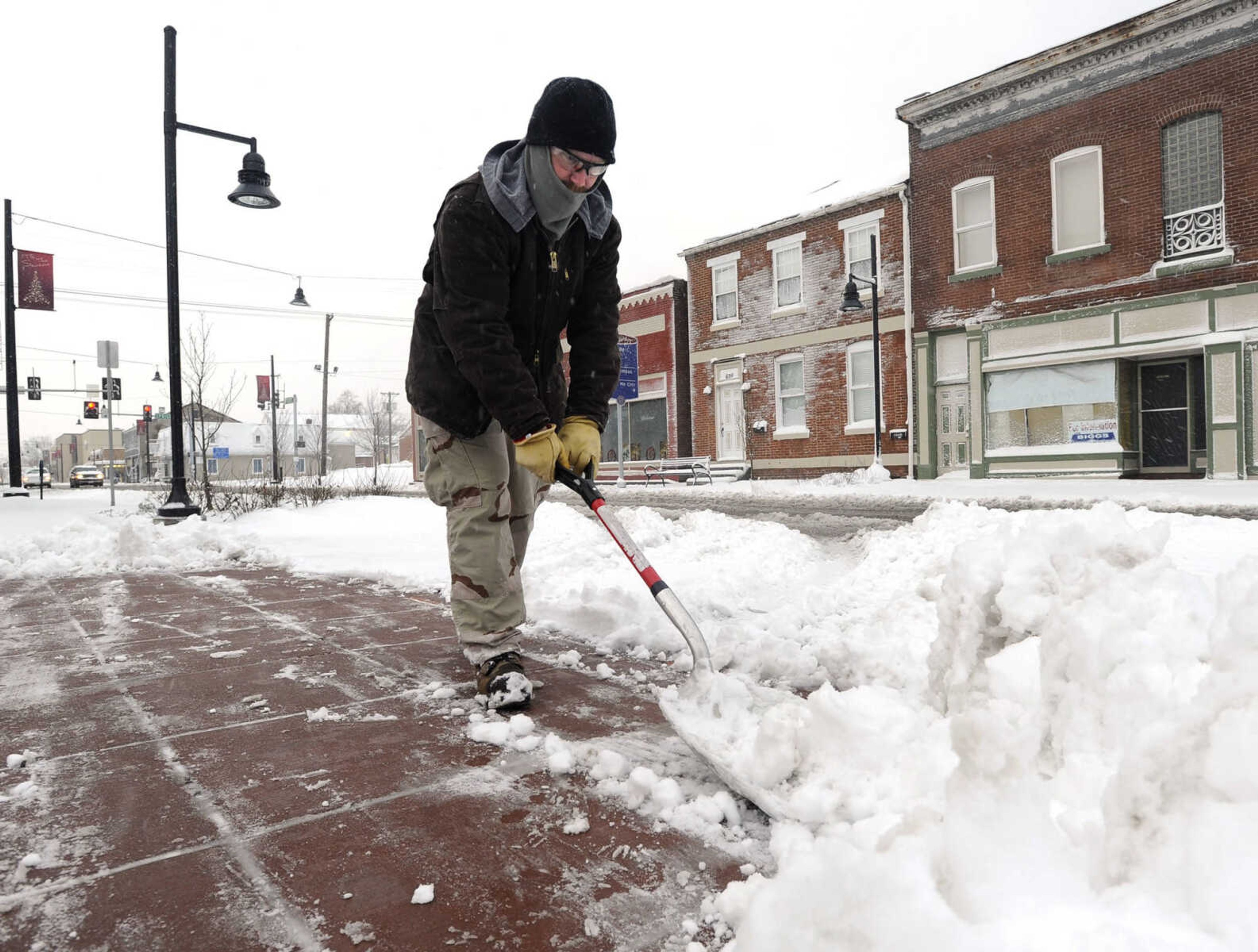 Shane Pridmore clears snow in the 600 block of Broadway Wednesday, Dec. 26, 2012 in Cape Girardeau. (Fred Lynch)