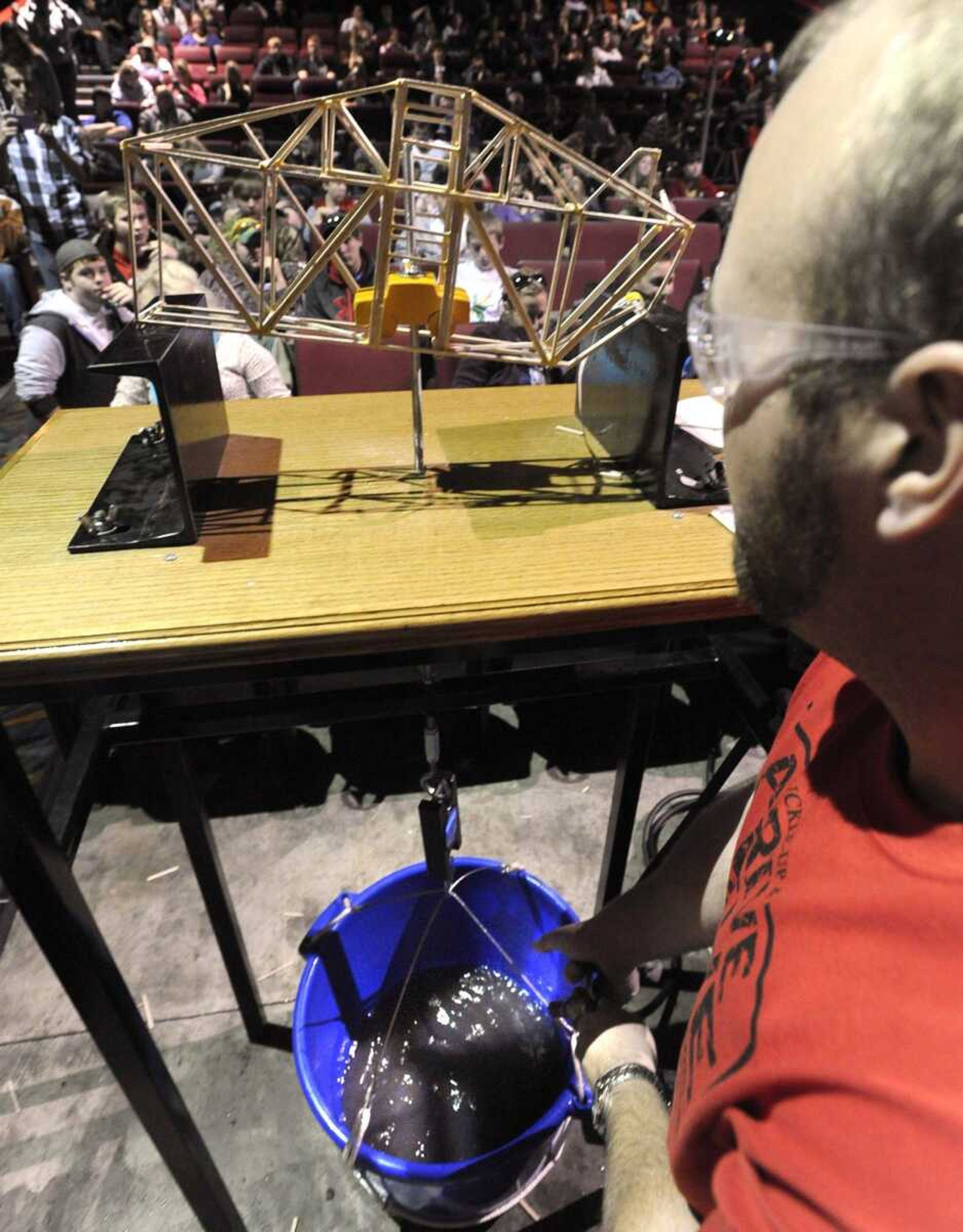 Seth Bollinger of the Missouri Department of Transportation stops the water to a bucket that caused the failure of a model bridge during the 2012 MoDOT bridge building competition Thursday at Cape West 14 Cine. (Fred Lynch)