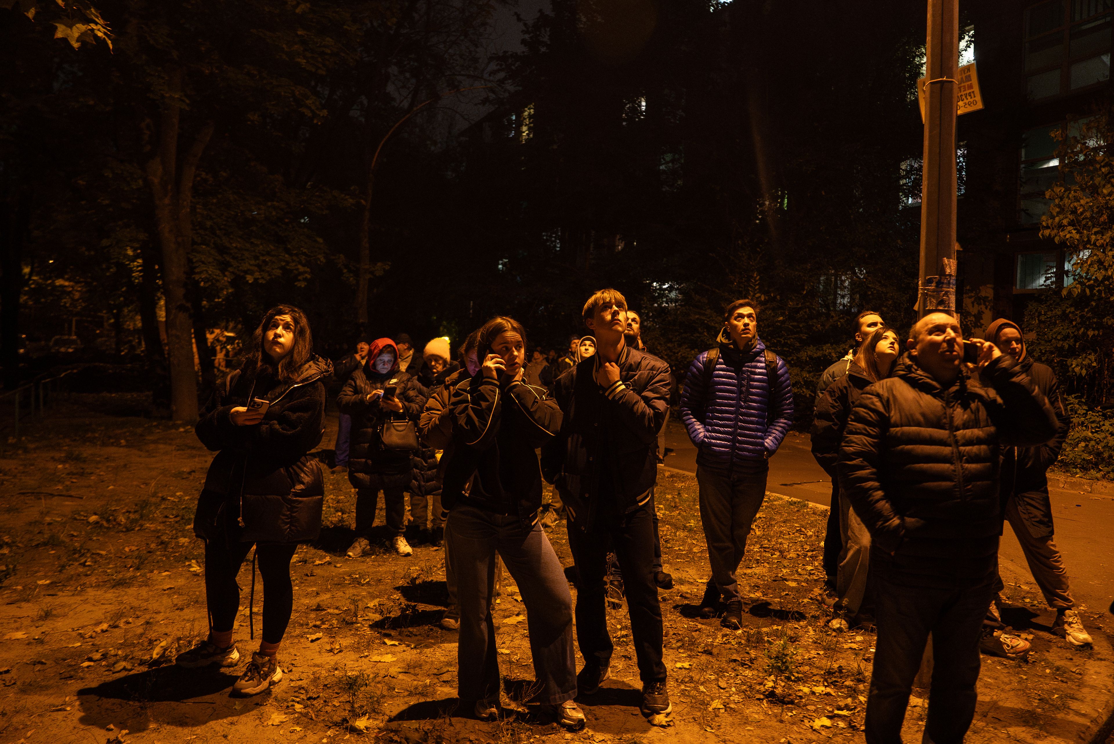 Local residents look up at the fire in a residential building after an attack of Russian drones in Kyiv, Ukraine, Friday, Oct. 26, 2024. (AP Photo/Alex Babenko)