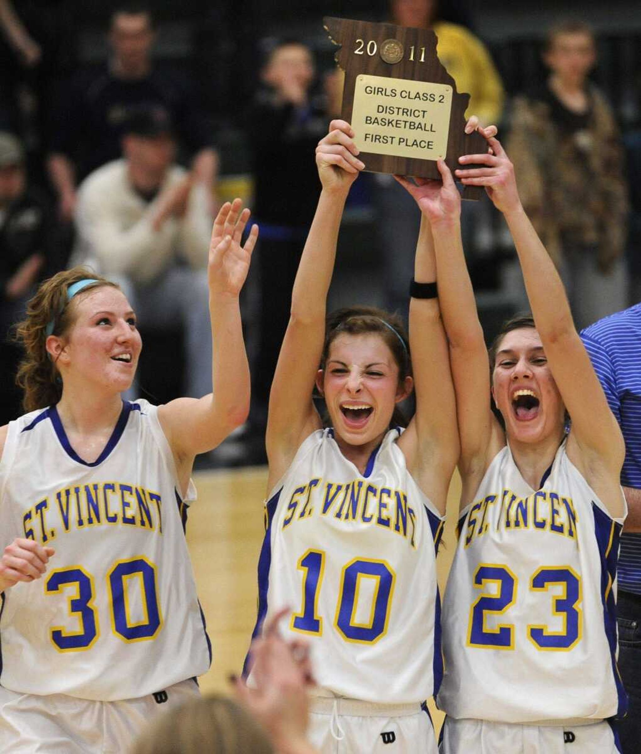 St. Vincent's Kali Wingerter, left, celebrates with Chelsie Boxdorfer and Kelci Besand as they hoist the district championship plaque after defeating New Haven in the Class 2 District 4 title game Friday in Perryville, Mo. (Fred Lynch)