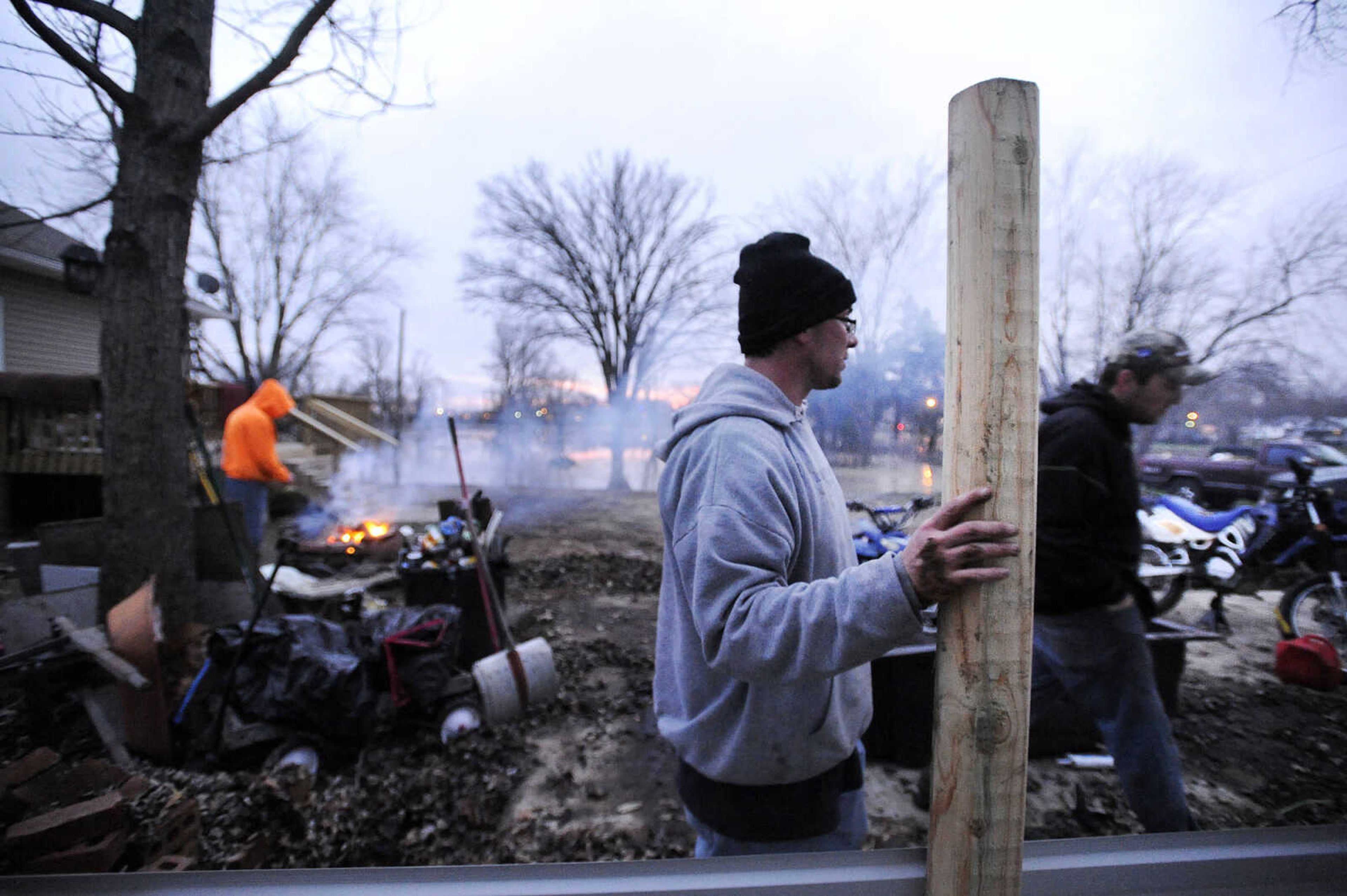 LAURA SIMON ~ lsimon@semissourian.com

Matt Butler works on a tin fence to surround a workshop near the Red Star Access in Cape Girardeau Tuesday evening, Dec. 29, 2015. Flooding from the Mississippi River is encroaching on the shop.