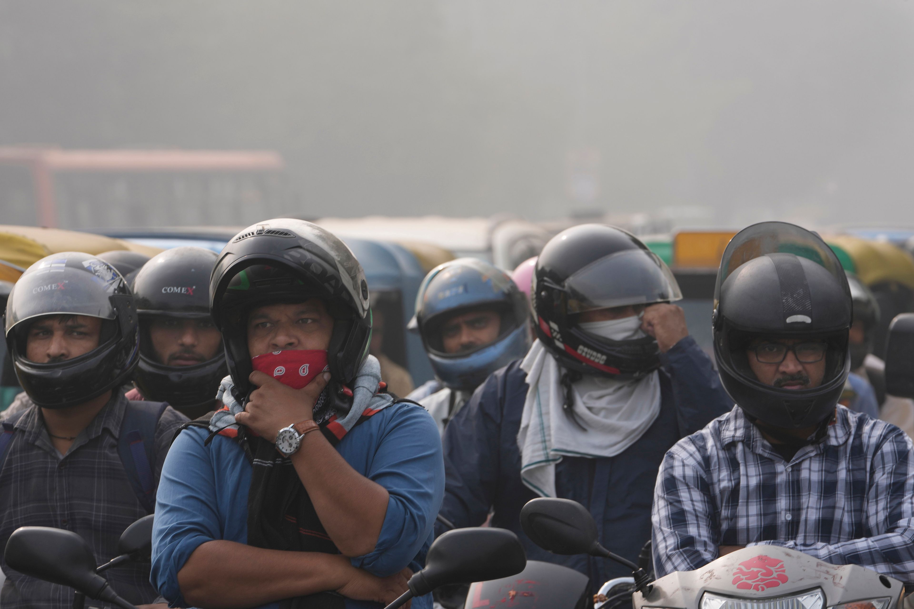 Commuters wait at a traffic signal surrounded by smog in New Delhi, India, Thursday, Nov. 14, 2024. (AP Photo/Manish Swarup)