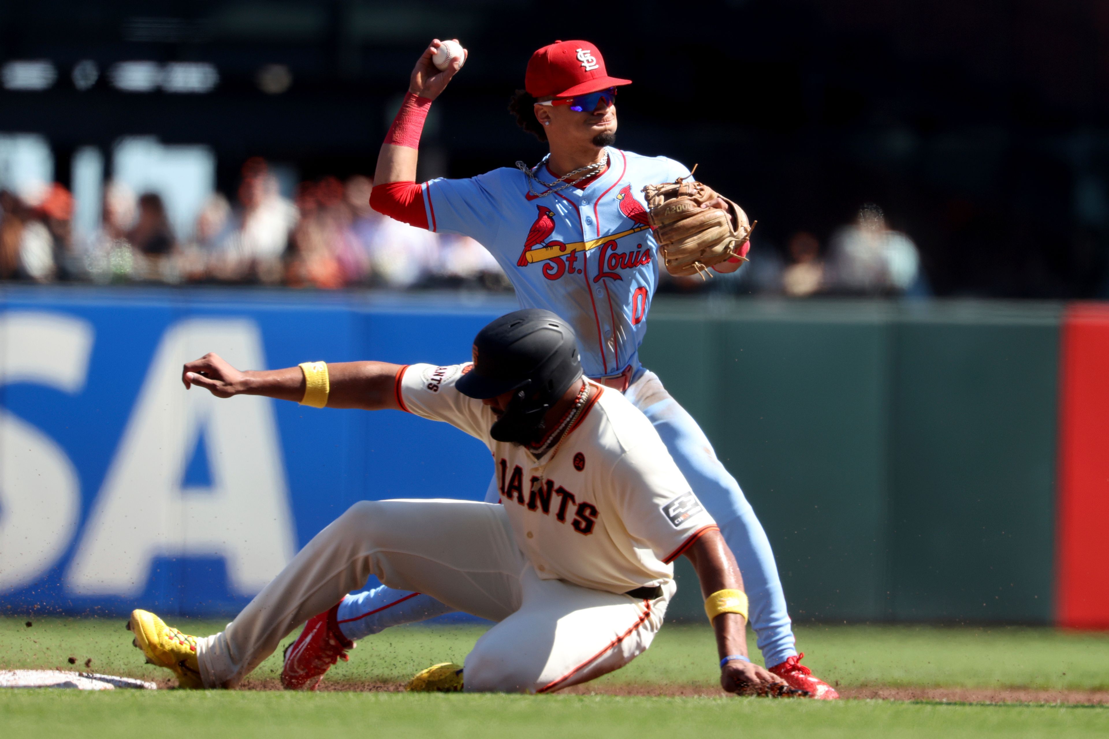 St. Louis Cardinals shortstop Masyn Winn (0) throws to first as San Francisco Giants' Jerar Encarnacion, left, slides into second on a double play hit by Patrick Bailey during the first inning of a baseball game in San Francisco, Saturday, Sept. 28, 2024. (AP Photo/Jed Jacobsohn)