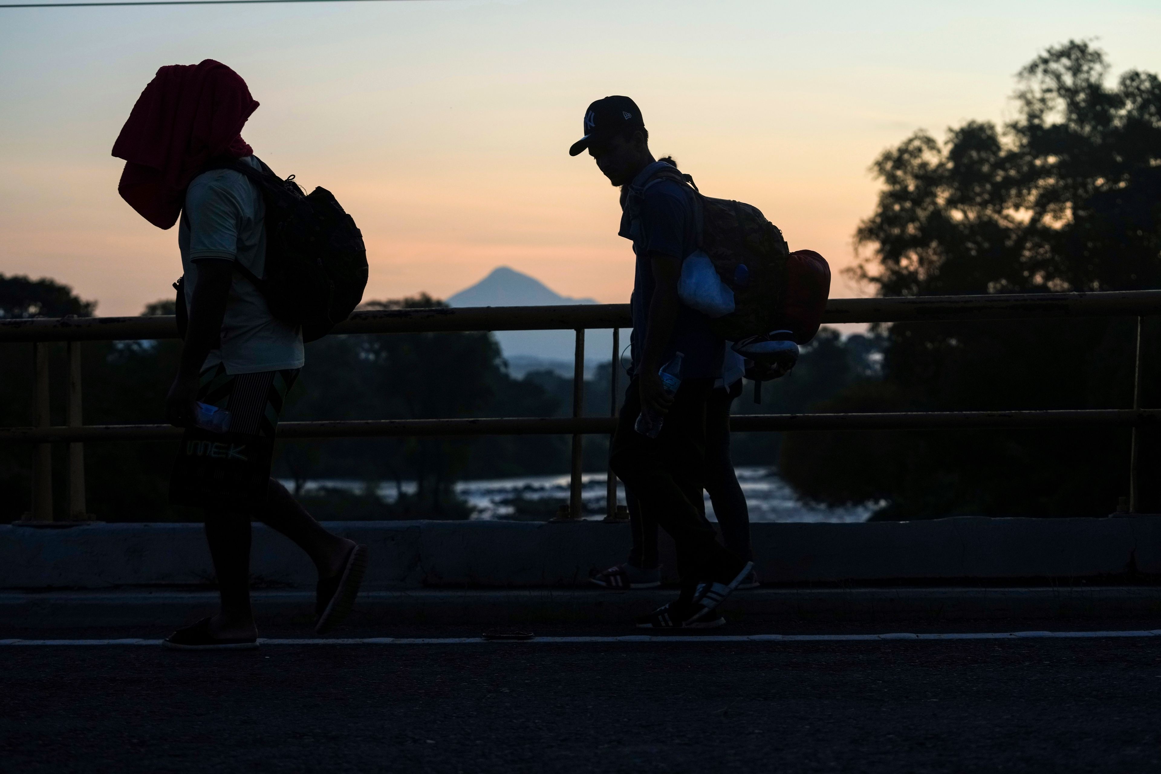 With the Tajumulco Volcano in the background, migrants walk along the Huixtla highway, in southern Mexico, Wednesday, Nov. 6, 2024, hoping to reach the country's northern border and ultimately the United States. (AP Photo/Moises Castillo)