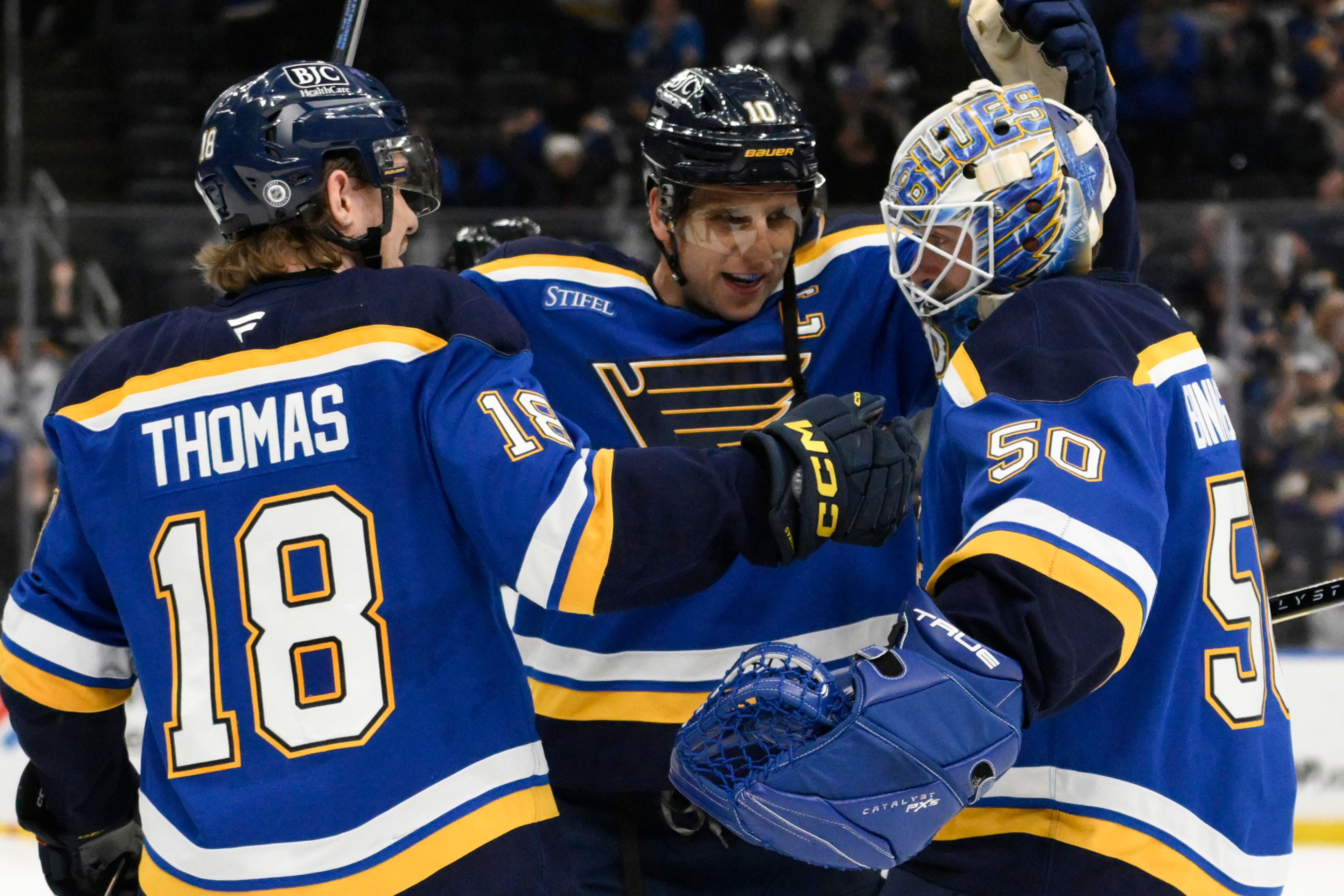 St. Louis Blues goaltender Jordan Binnington, right, is congratulated by center Brayden Schenn, center, and center Robert Thomas, left, after defeating the San Jose Sharks in the shootout of an NHL hockey game Thursday, Nov. 21, 2024, in St. Louis. (AP Photo/Jeff Le)