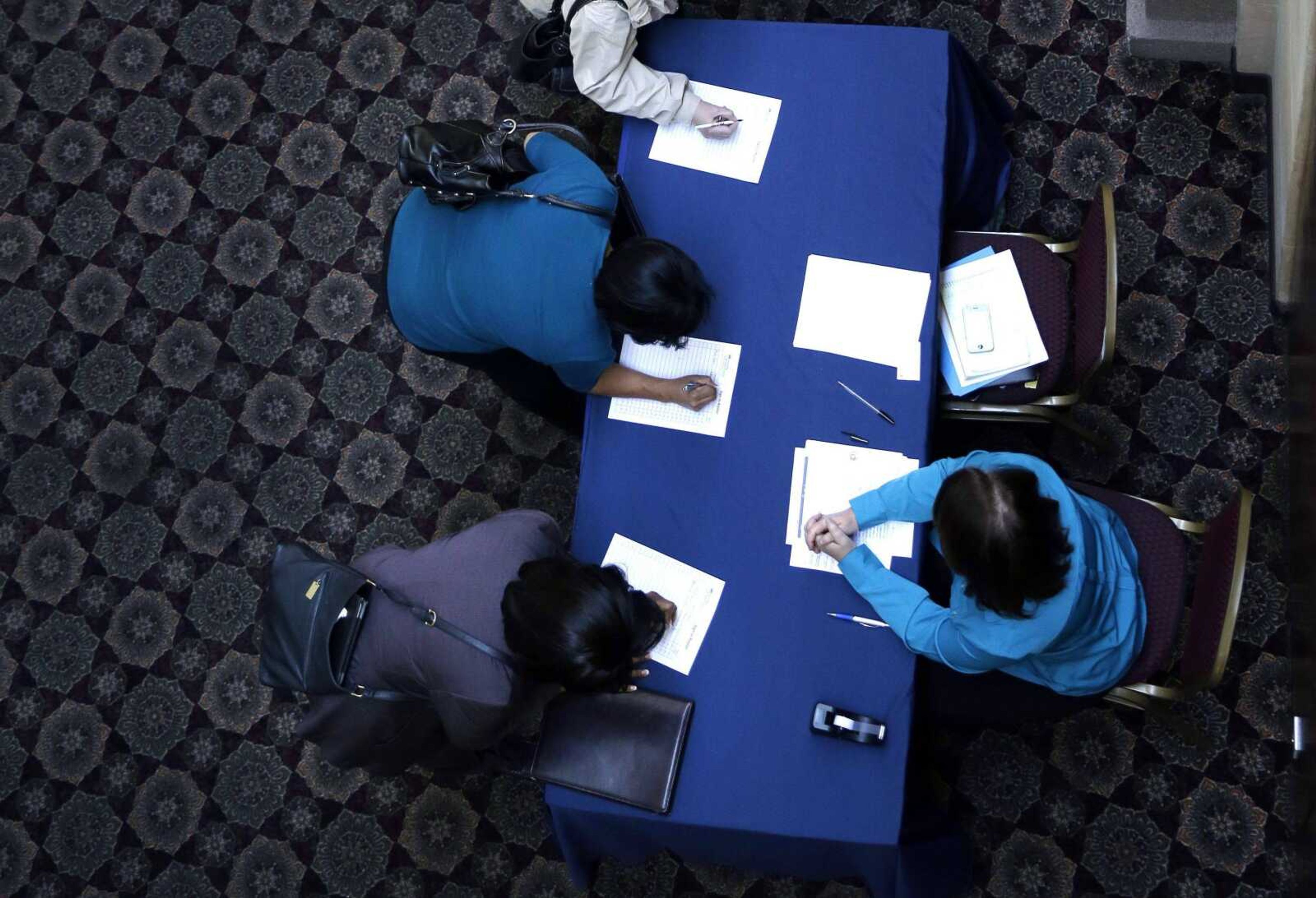 Job-seekers line up to sign in before meeting prospective employers at a career fair Jan. 22 at a hotel in Dallas. (LM Otero ~ Associated Press)