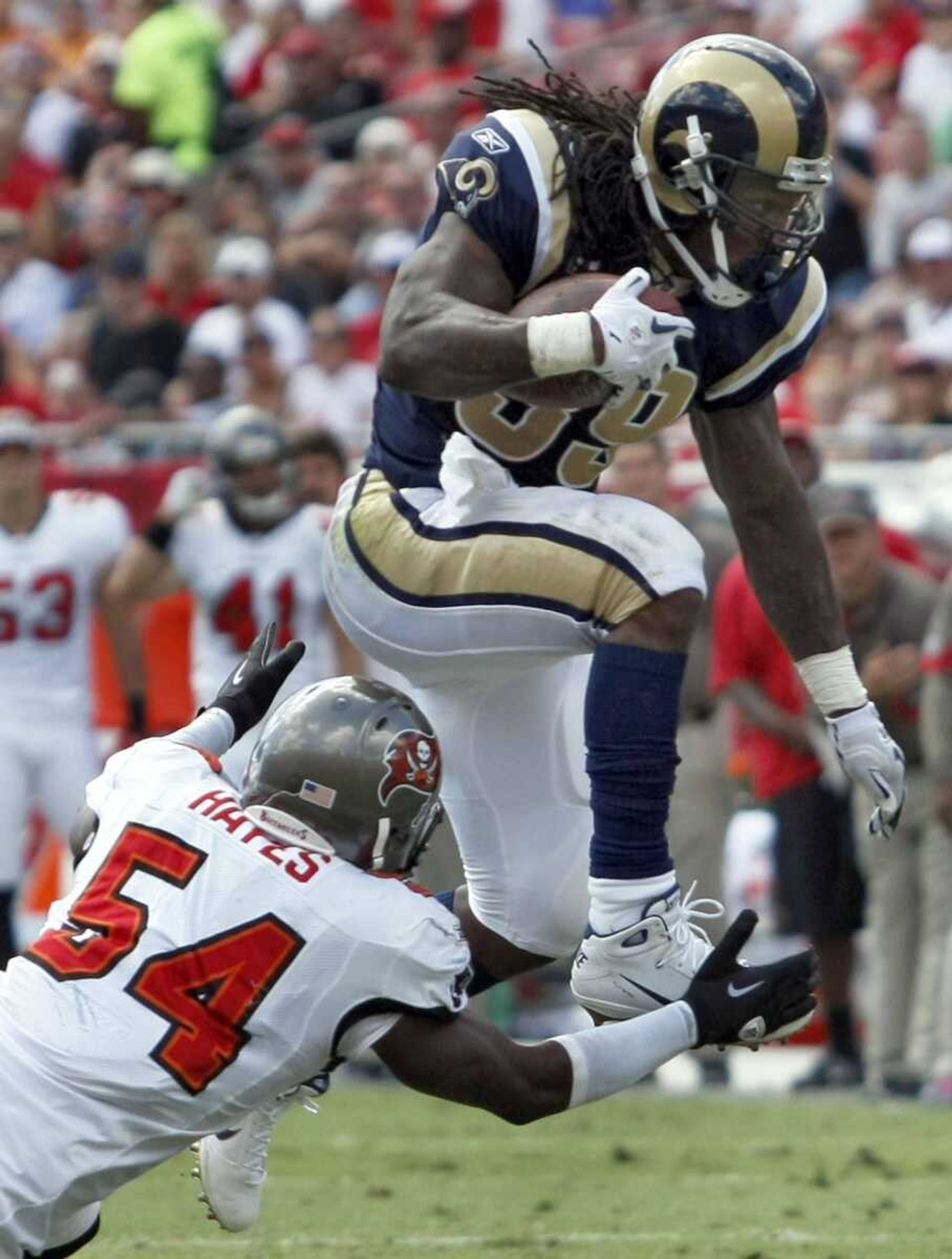 Rams running back Steven Jackson leaps over Buccaneers linebacker Geno Hayes on a second-quarter run Sunday in Tampa, Fla. Jackson became the Rams' career rushing leader during the quarter, surpassing Eric Dickerson. (Chris O'Meara ~ Associated Press)