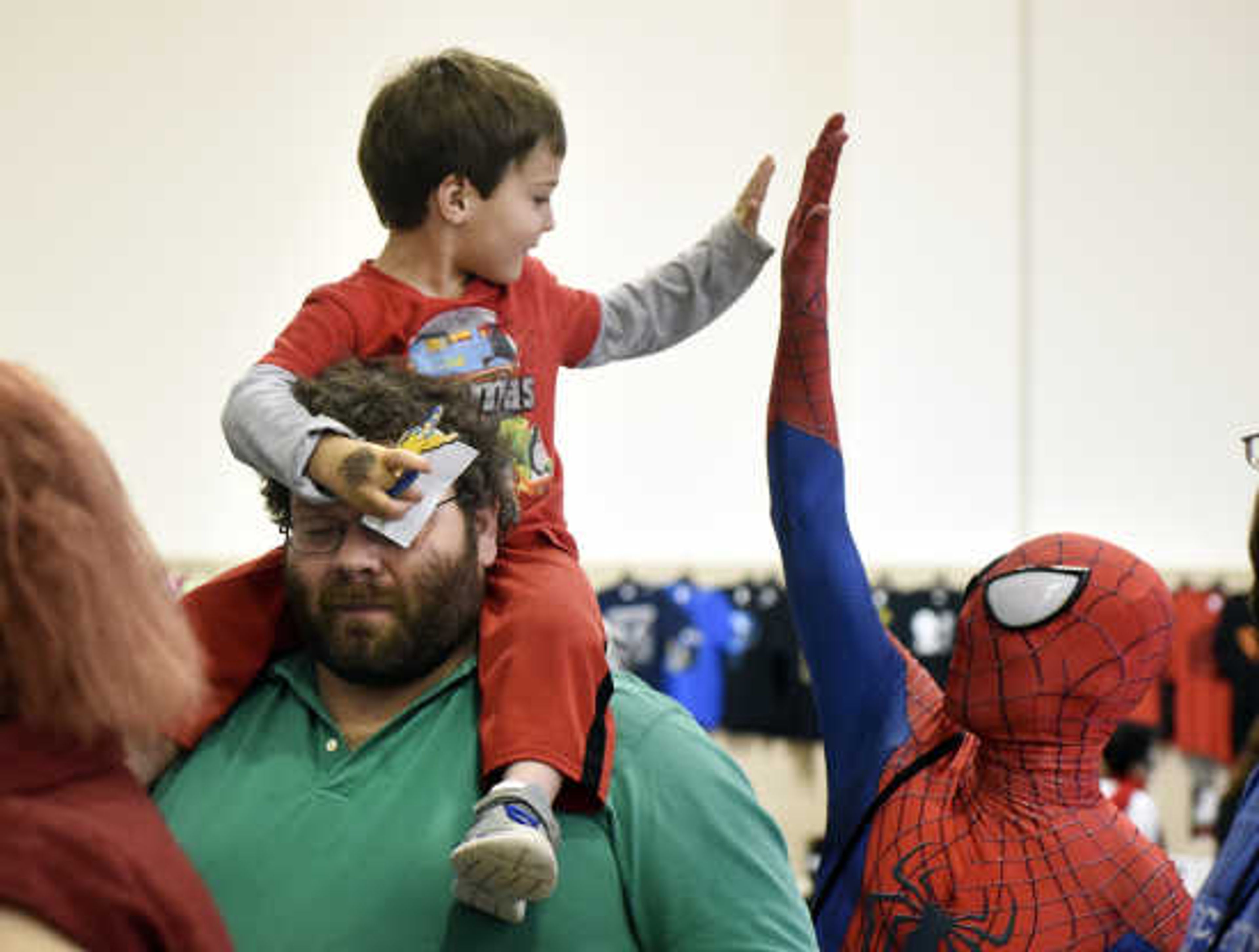 Spiderman gives C.J. Simpson a high-five as he is perched upon Lester Tucker's shoulders during the 12th annual Cape Comic Con on Saturday, April 22, 2017, at the Osage Centre in Cape Girardeau.