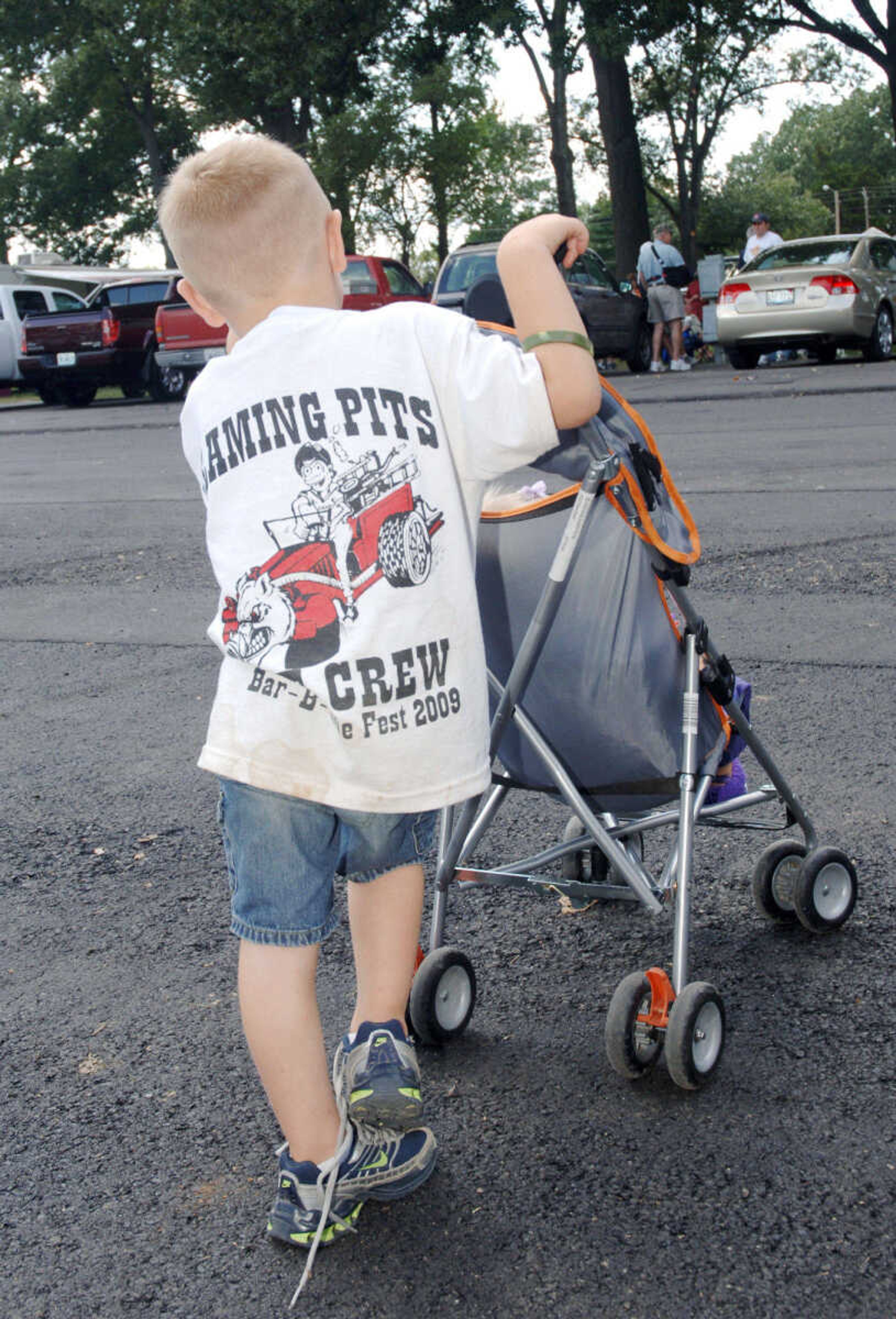 Tucker Stewart of the Flaming Pits Crew, pushes Danica Dewrock in her stroller at the Cape BBQ Fest Saturday, August 22, 2009, at Arena Park.