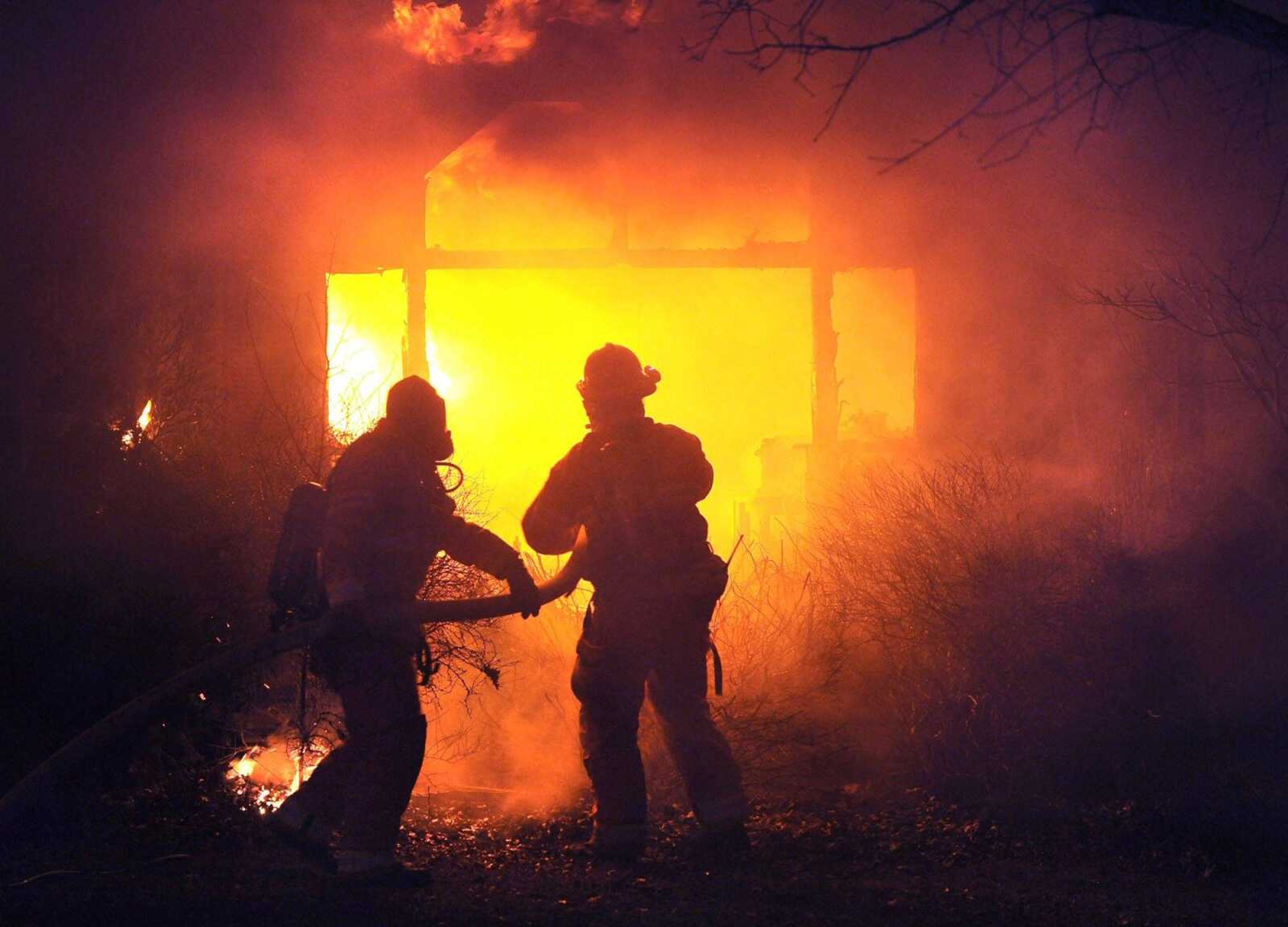 Firefighters attack a fire at a mobile home Saturday night near Fruitland that killed a woman who lived there.