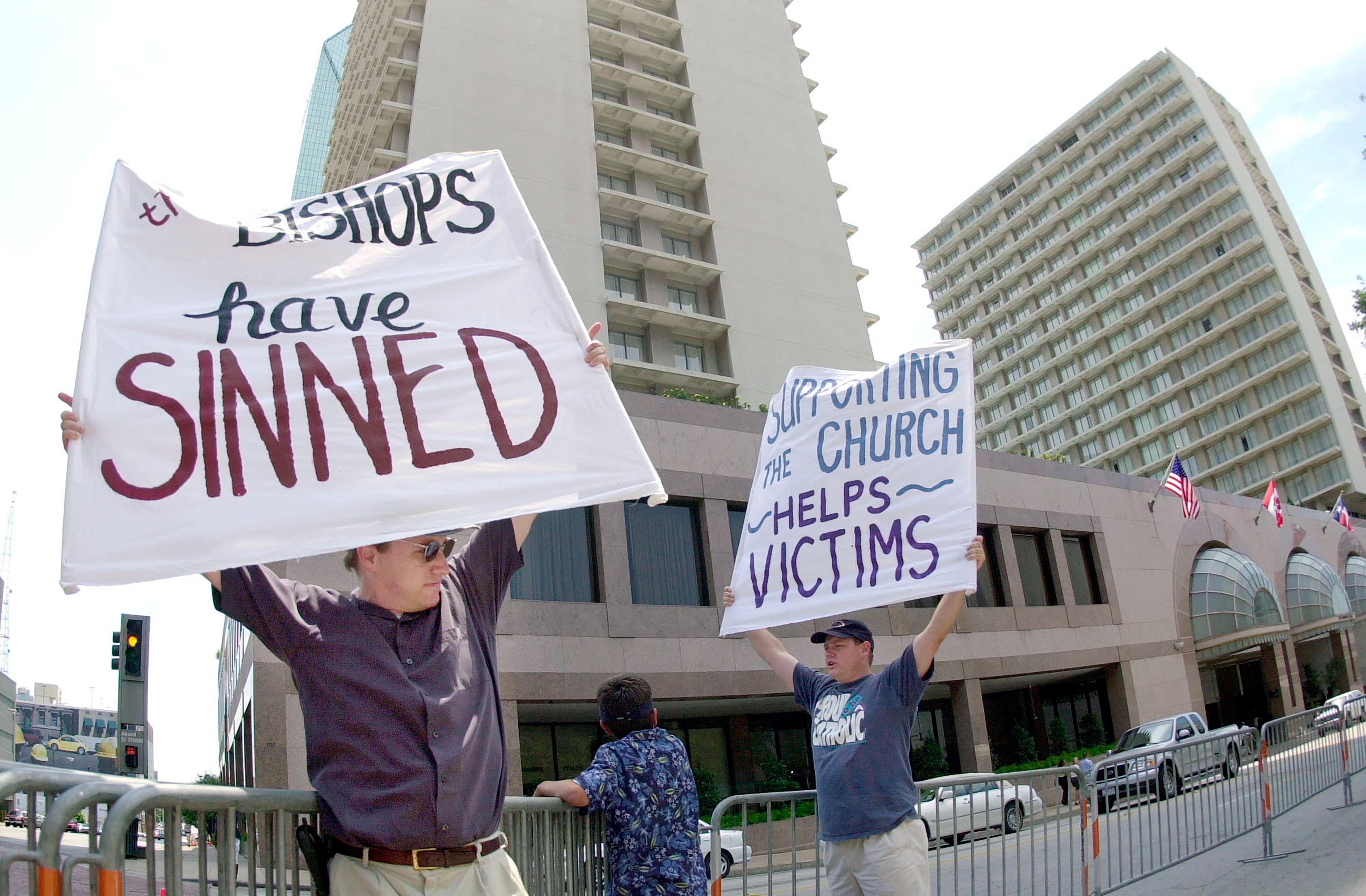 FILE - Dave West, left, and his brother Larry West, both of Fort Worth, Texas, demonstrate outside the hotel where the U.S. Conference of Catholic Bishops are meeting in Dallas on June 14. 2002. (AP Photo/Charlie Riedel, File)