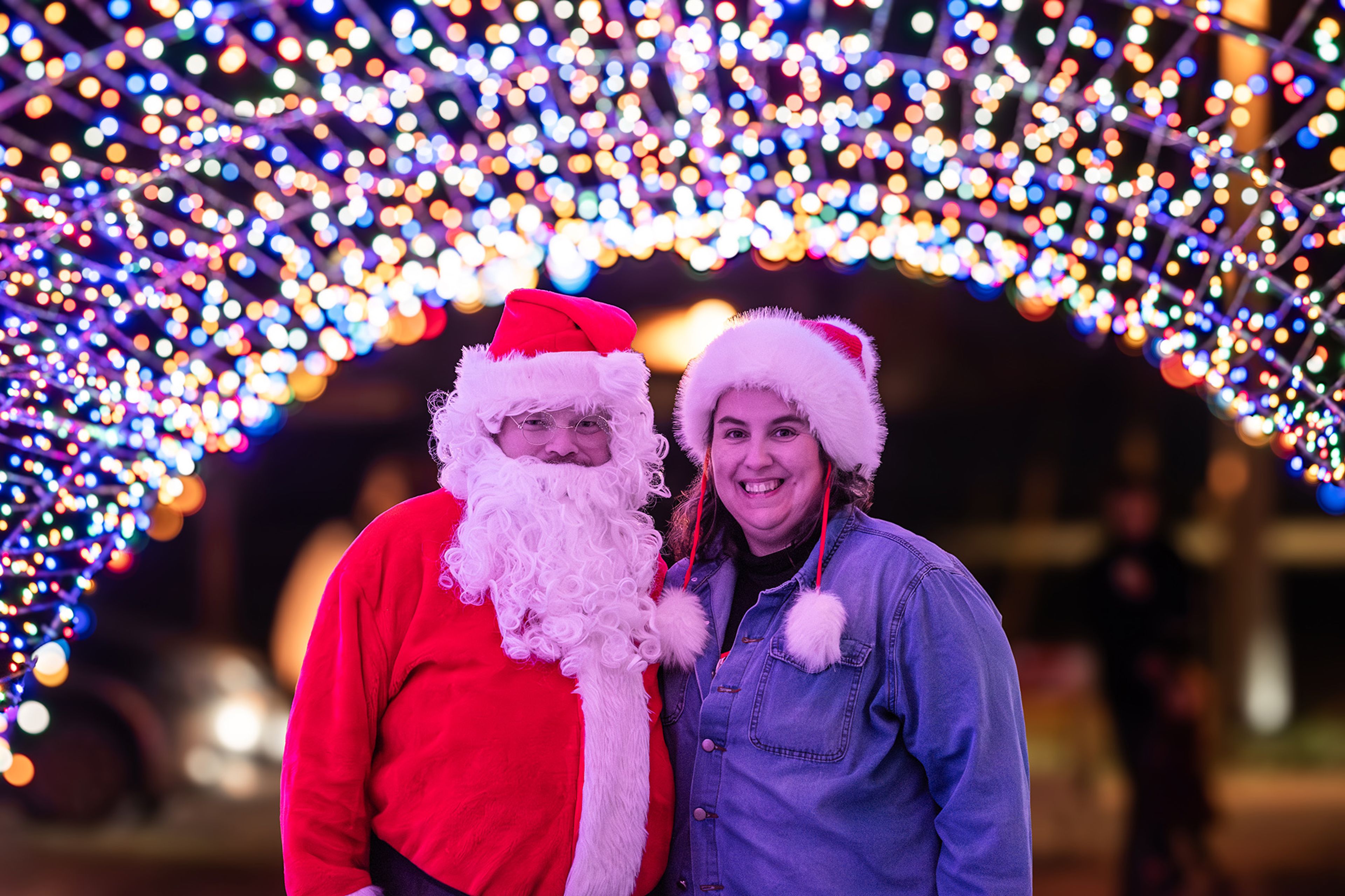 The mayor of Marble Hill and his wife, Trey and Becky Wiginton, stand beneath a glowing arch of Christmas lights, soaking in the holiday spirit.
