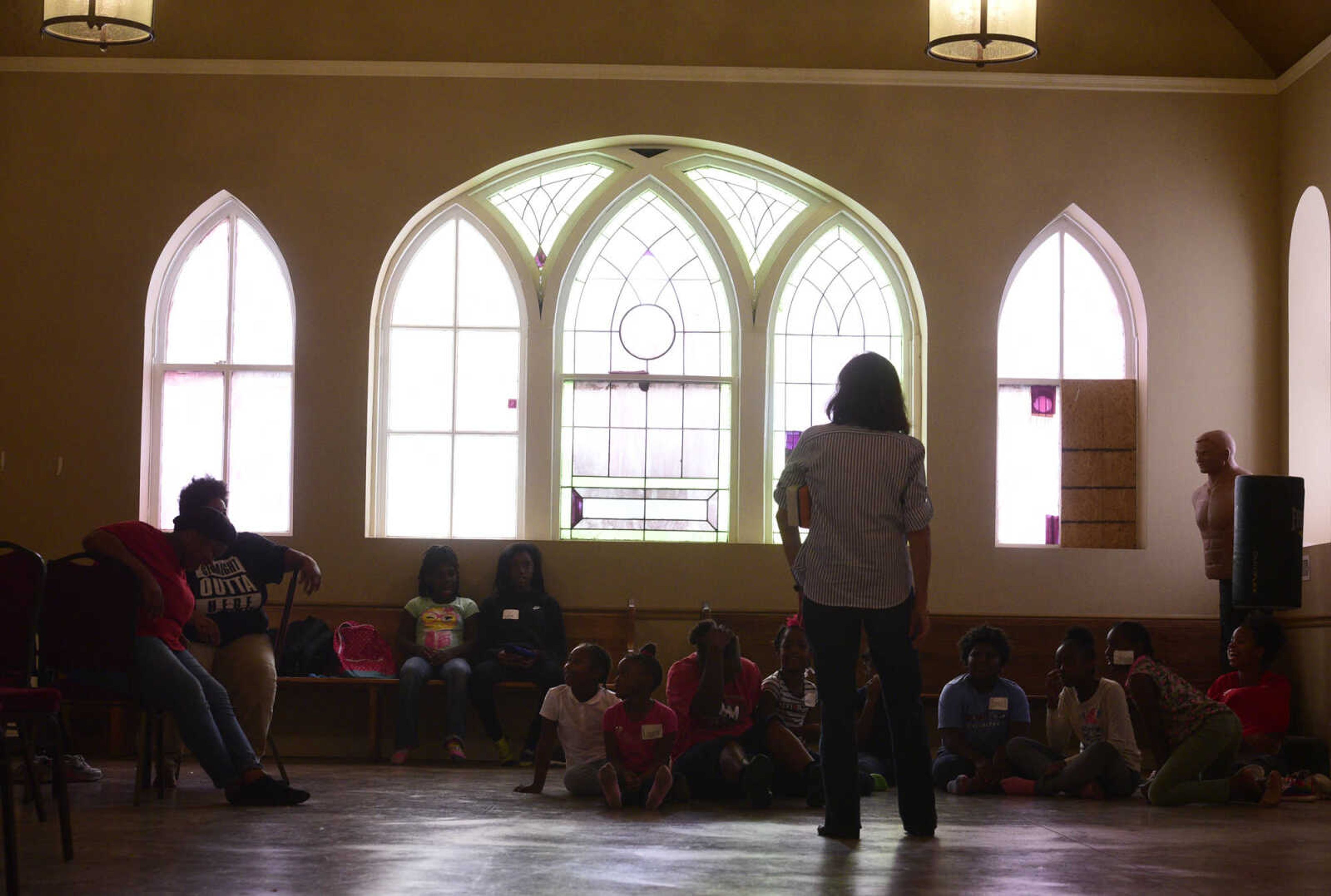 Students listen to Debbie Bowers speak before dinner on Monday, Aug. 14, 2017, during the Salvation Army's after school program at The Bridge Outreach Center in Cape Girardeau.