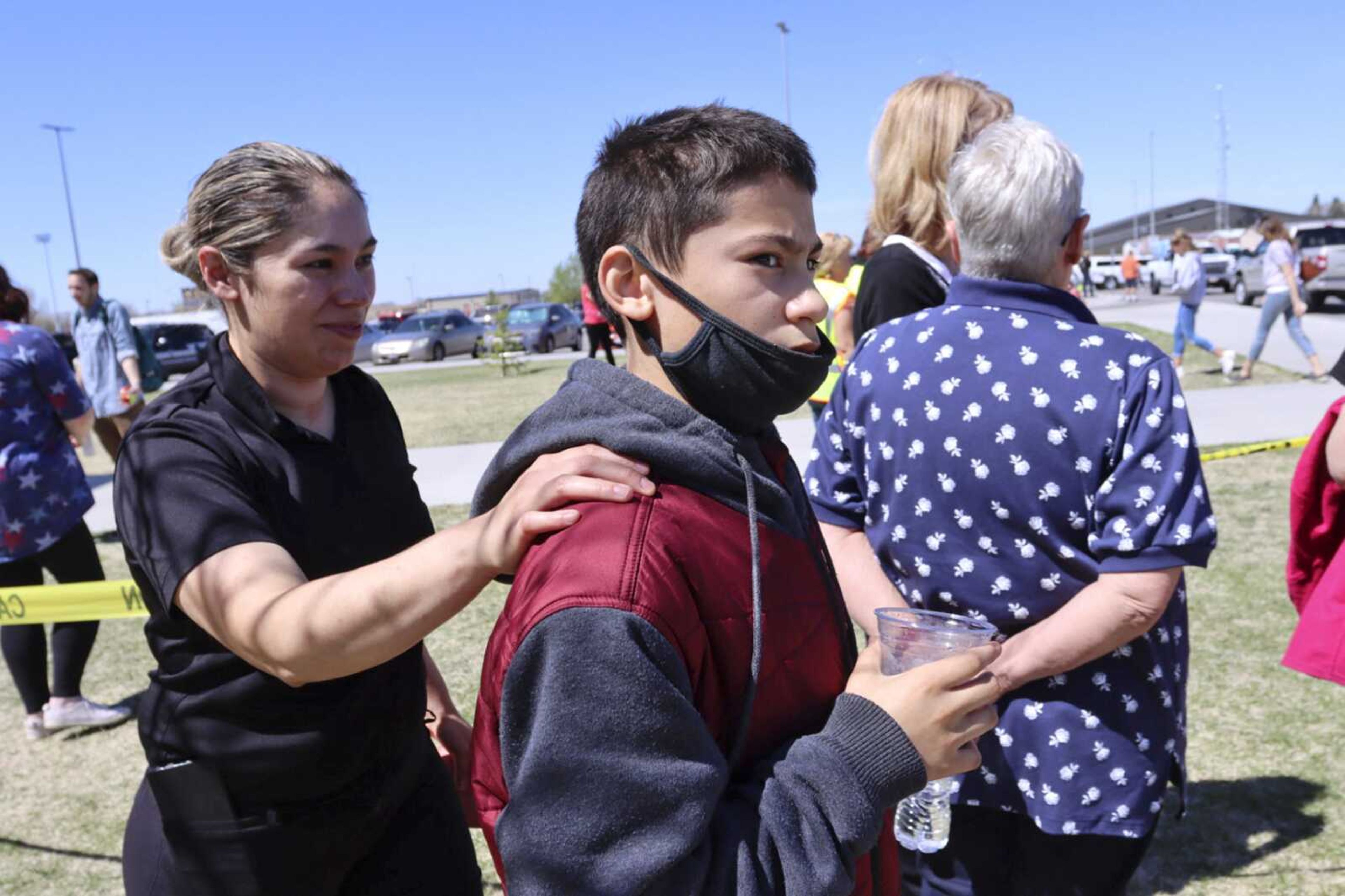 Adela Rodriguez, left, walks with her son, Yandel, 12, at the high school where people were evacuated after a shooting at the nearby Rigby Middle School earlier Thursday in Rigby, Idaho.