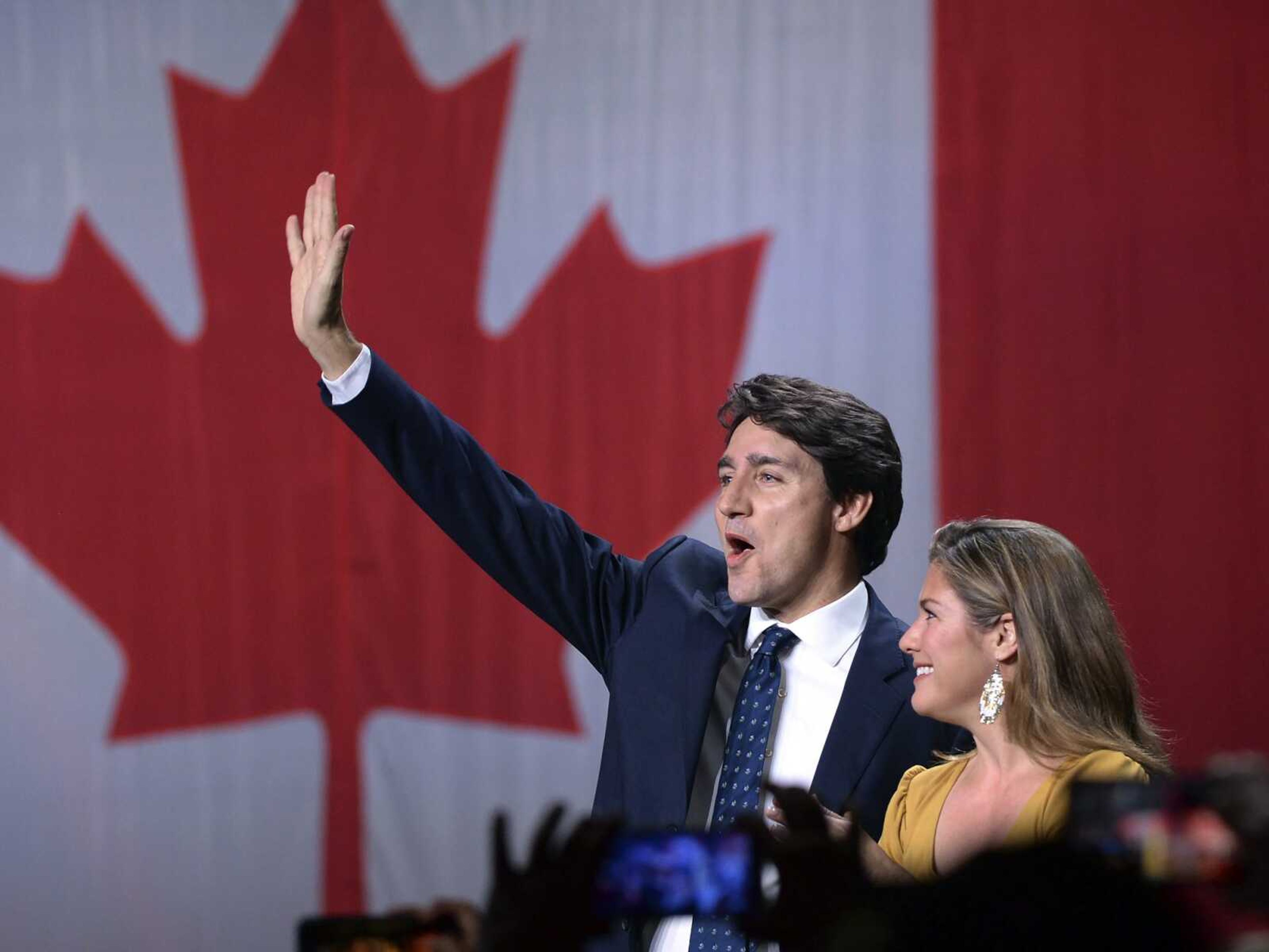 Liberal leader Justin Trudeau and wife Sophie Gregoire Trudeau wave as they go on stage at Liberal election headquarters Monday in Montreal.