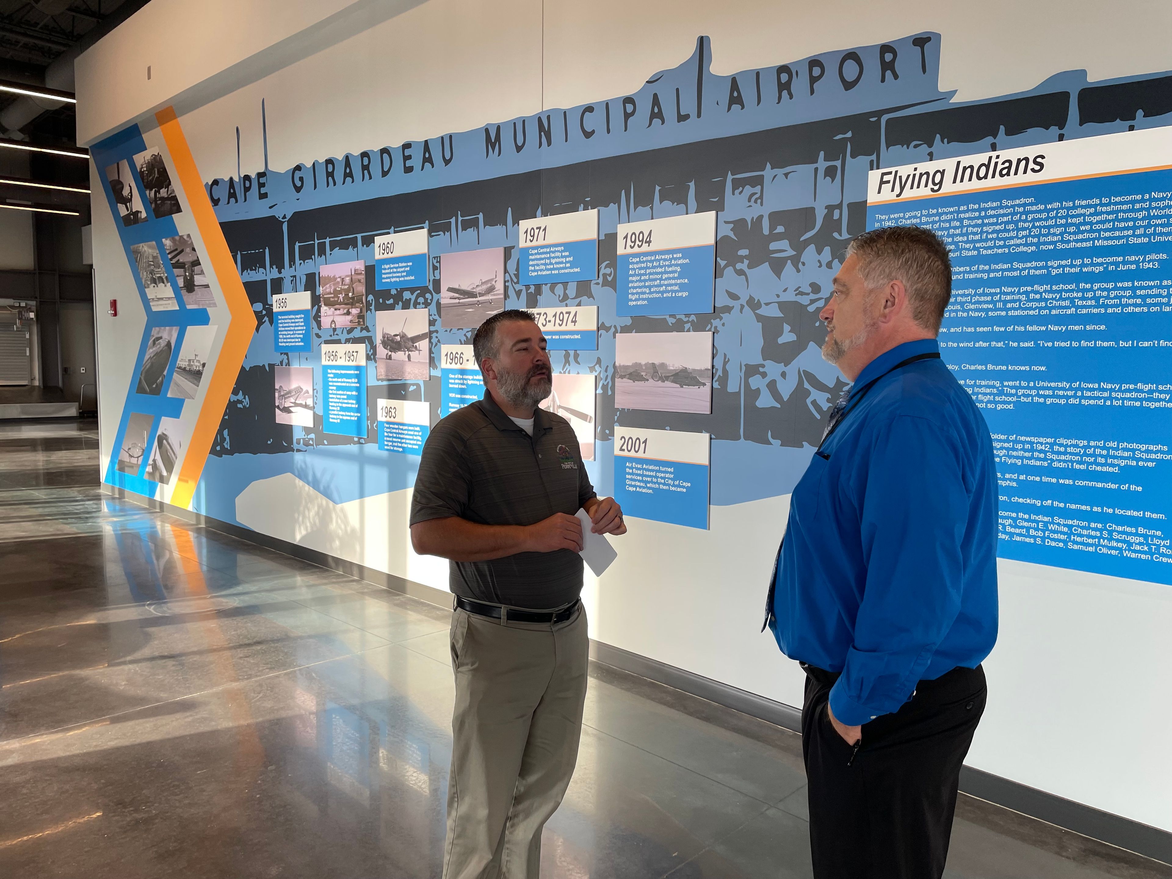 Brett Buerck of Perryville and newly appointed Airport Manager JoJo Stuart stand in front of a historical timelines of the Cape Girardeau Regional Airport, formerly known as Cape Girardeau Municipal Airport.