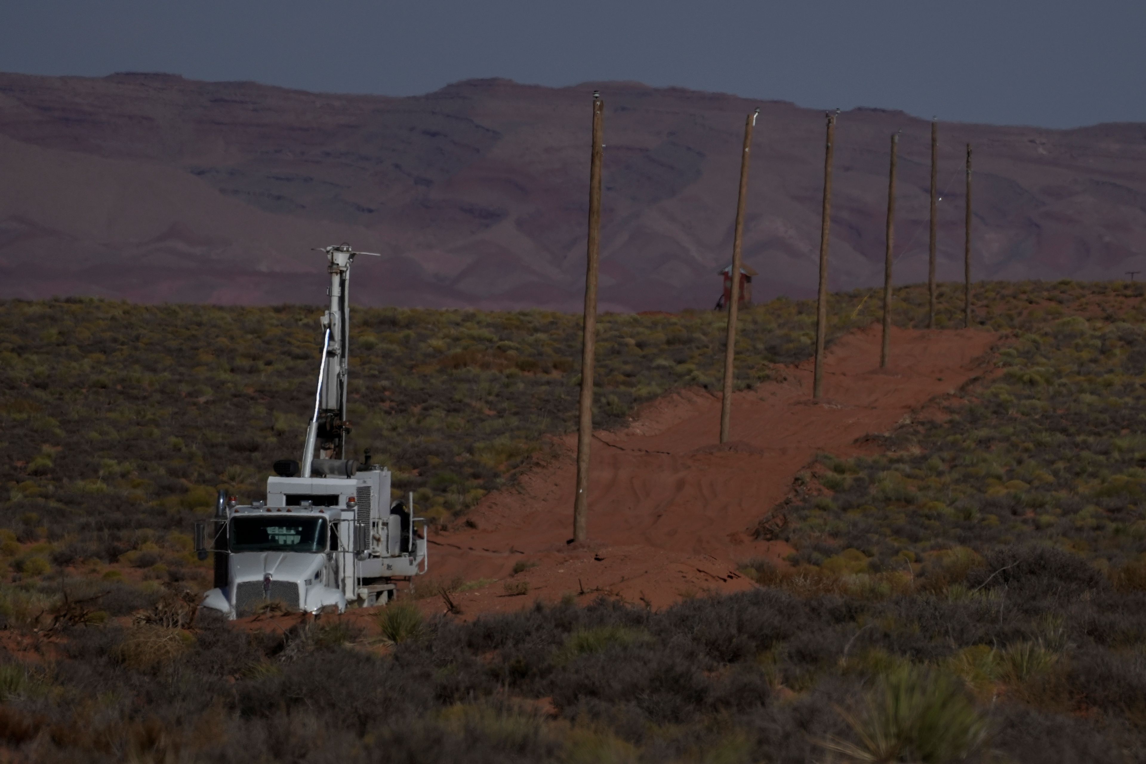 A crew with the Navajo Tribal Utility Authority installs power poles, Wednesday, Oct. 9, 2024, on the Navajo Nation in Halchita, Utah. (AP Photo/Joshua A. Bickel)