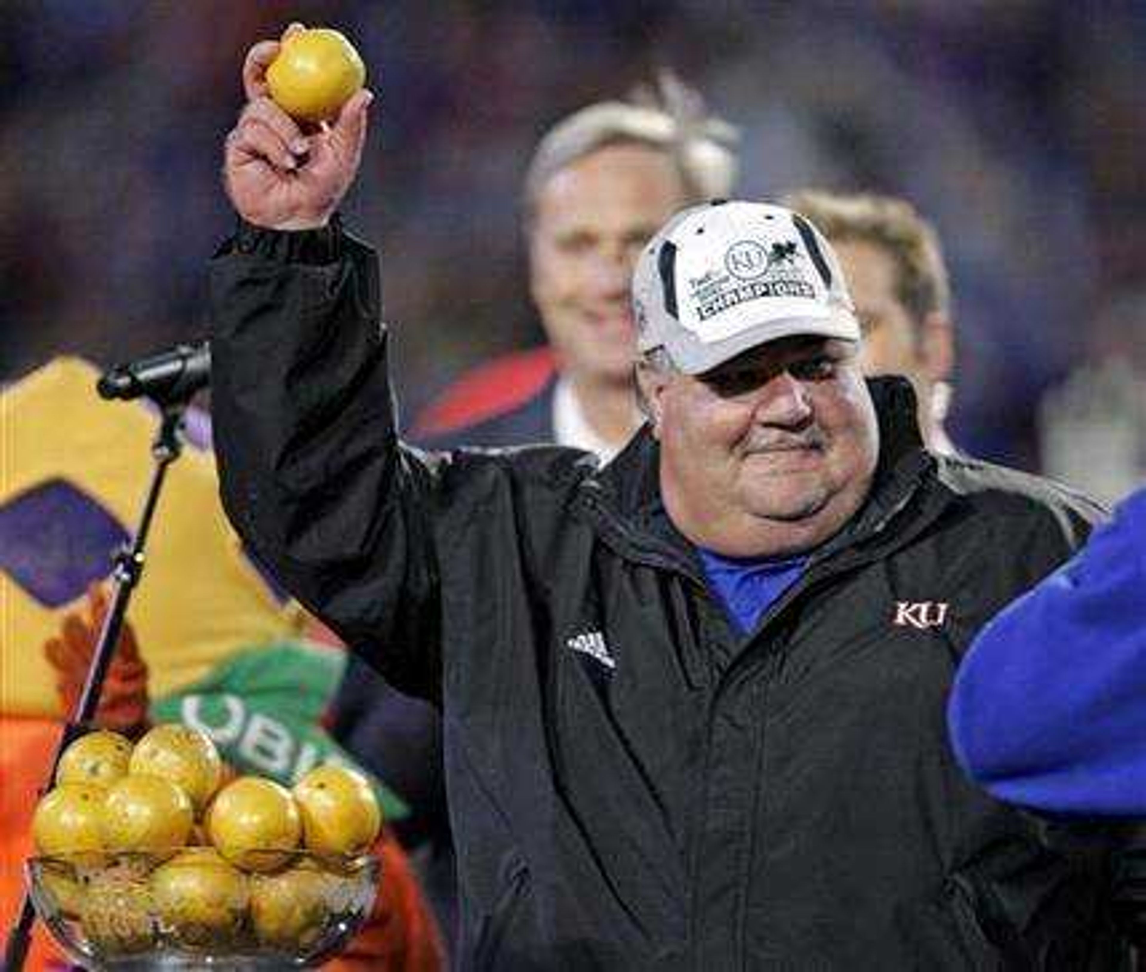 Kansas head football coach Mark Mangino holds an orange from one of he trophies after their 24-21 win over Virginia Tech in the Orange Bowl college football game at Dolphin Stadium in Miami, Thursday Jan. 3, 2008.  (AP Photo/Steve Helber)