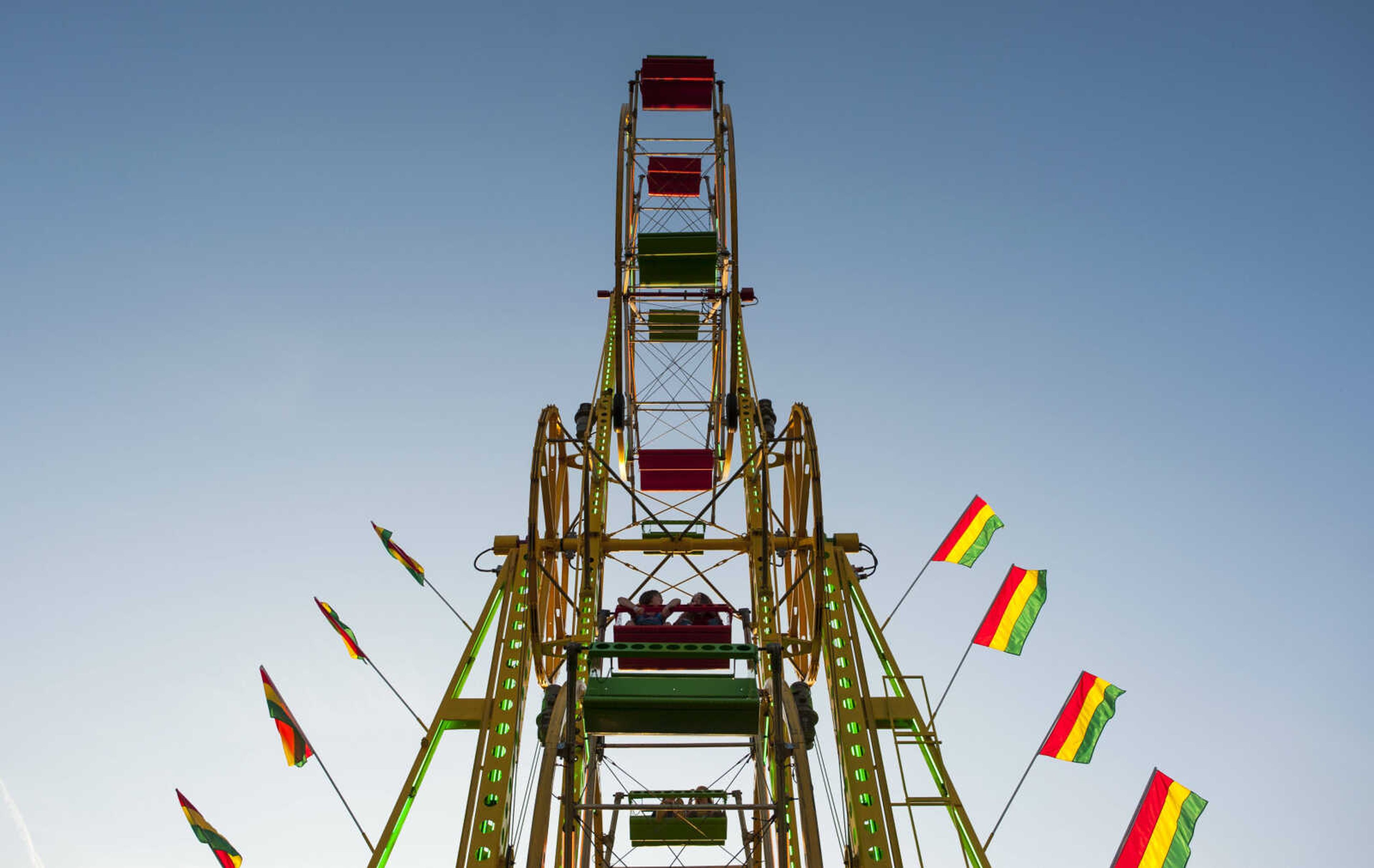 Riders sit aboard Miller's Sky Wheel, a double Ferris wheel attraction, as it spins in the midway Tuesday, Sept. 10, 2019, during the SEMO District Fair at Arena Park in Cape Girardeau.